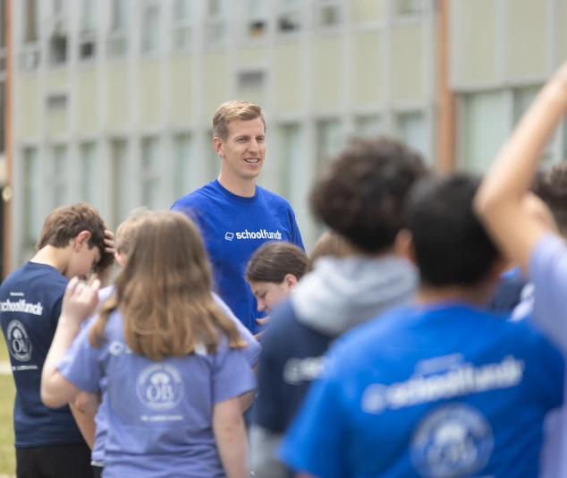 CEO of School Funder with students from a school.