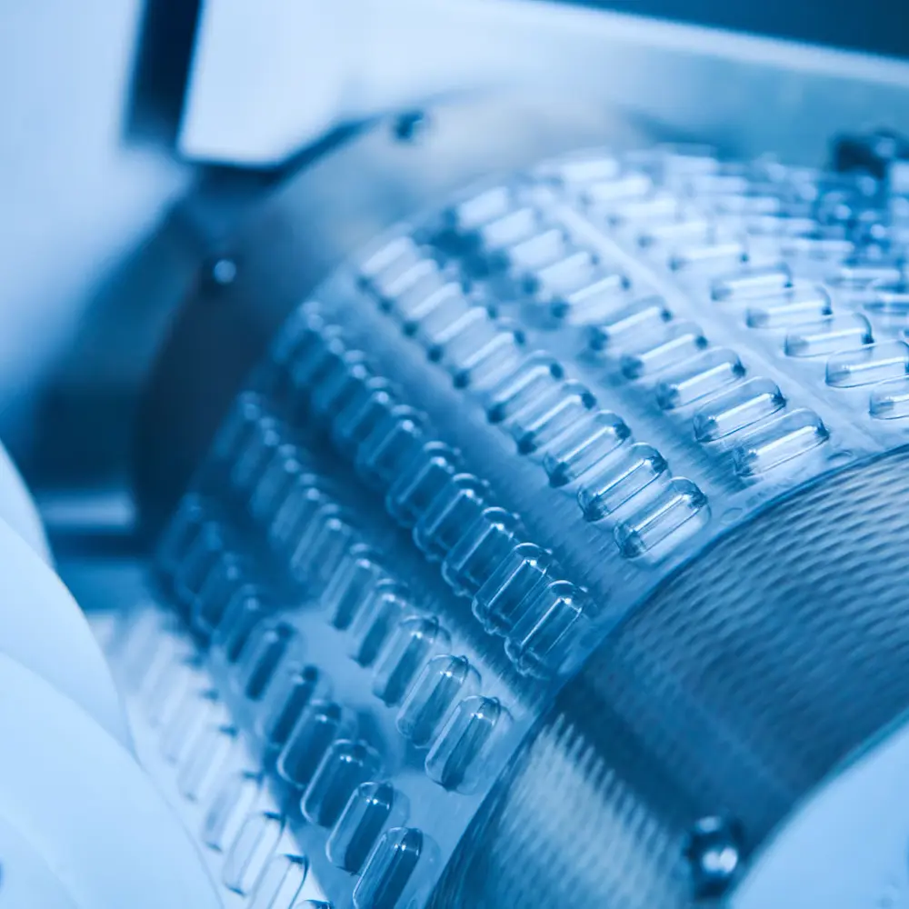 Automated pharmaceutical manufacturing equipment producing precision medical components in a modern facility.