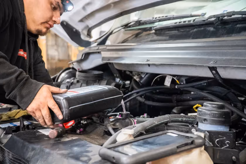 Diesel mechanic performing oil and fluid services in Fontana, CA