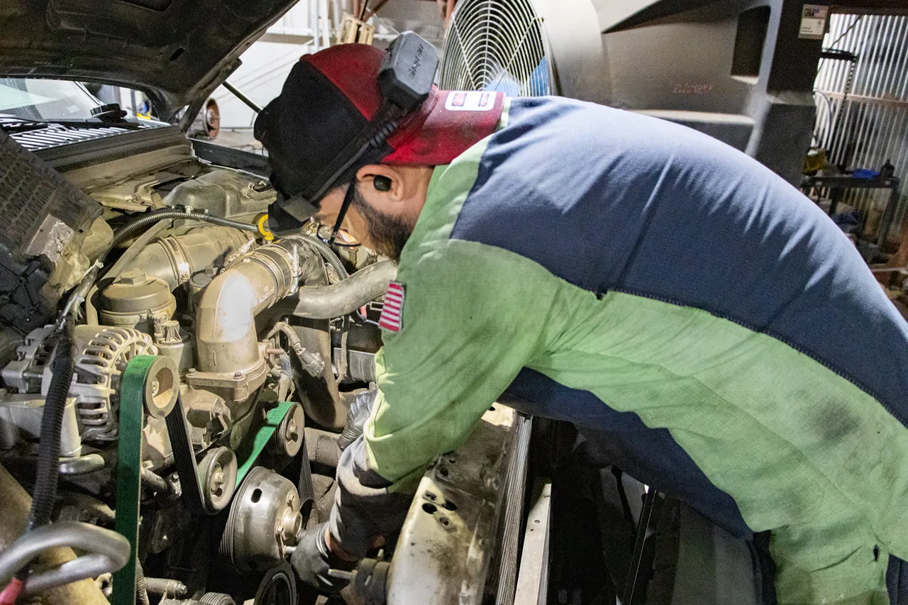 Heavy-duty repair technician inspects a commercial truck engine in Fontana before the fall freight rush.