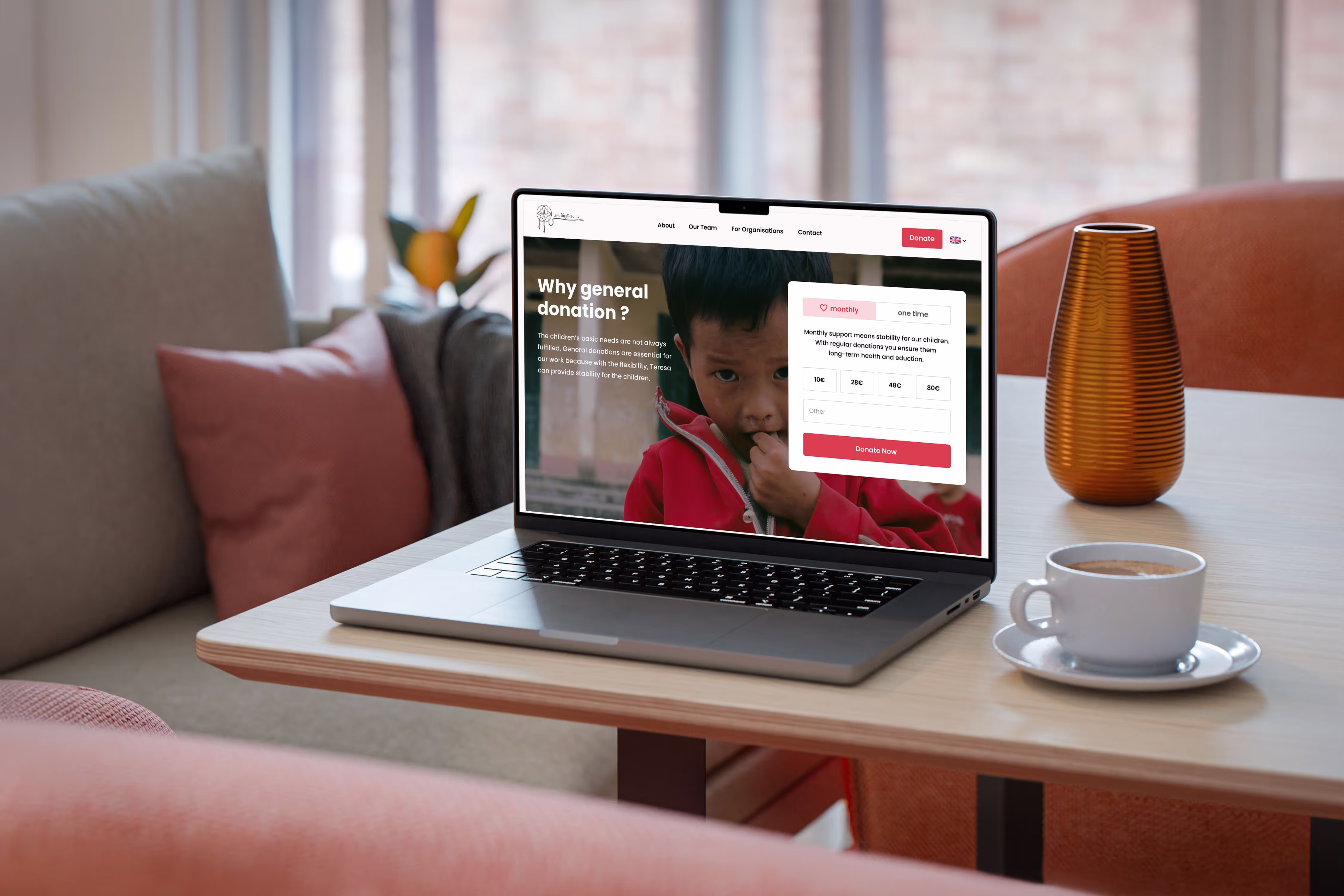 Laptop on a table showing website for NGO in Hamburg with image of a child and red accents