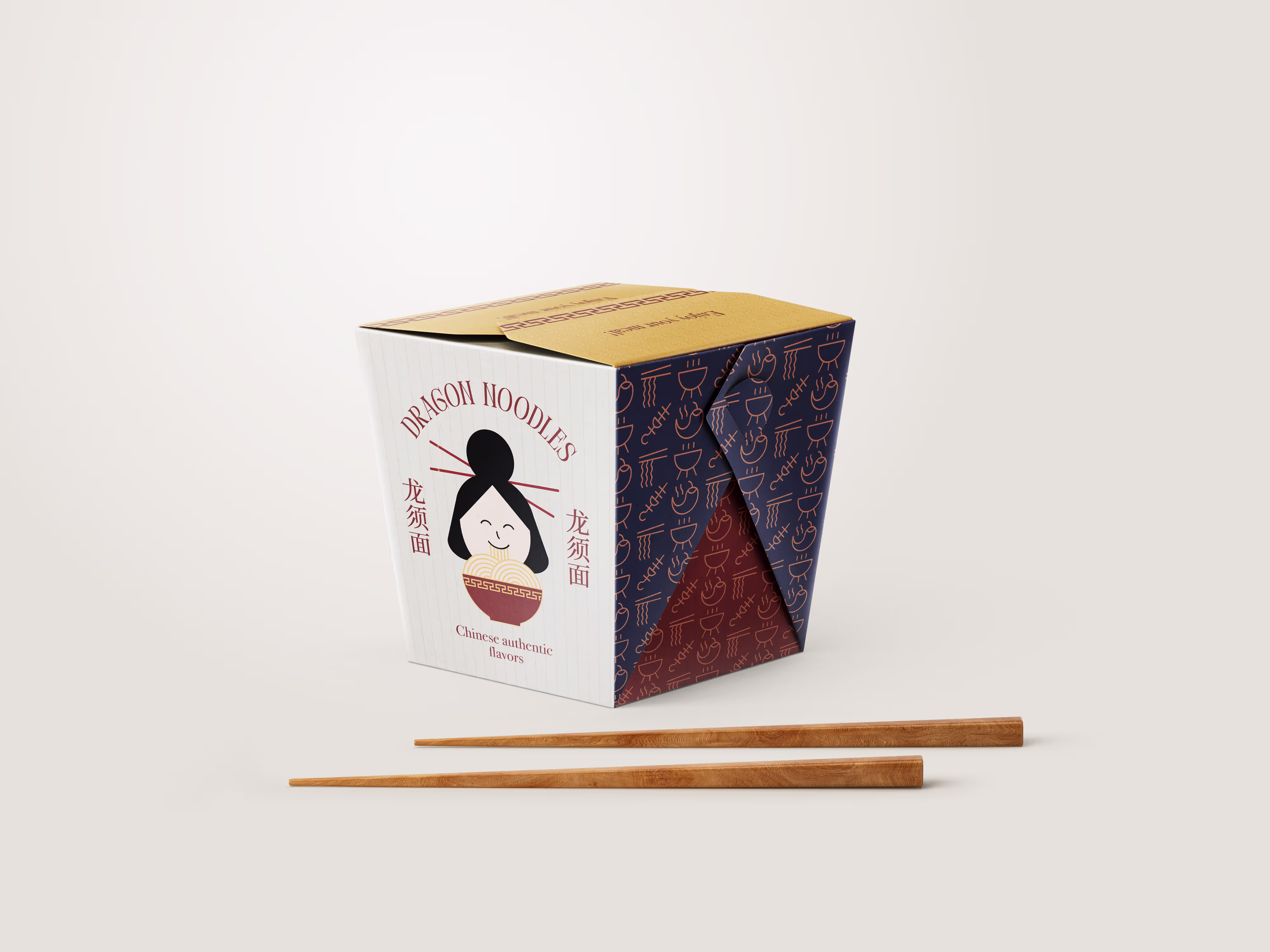 A white and maroon takeout box for "Dragon Noodles" with a cartoon illustration of a person with chopsticks in their hair eating noodles. A pair of wooden chopsticks rests in front of the box on a light gray surface