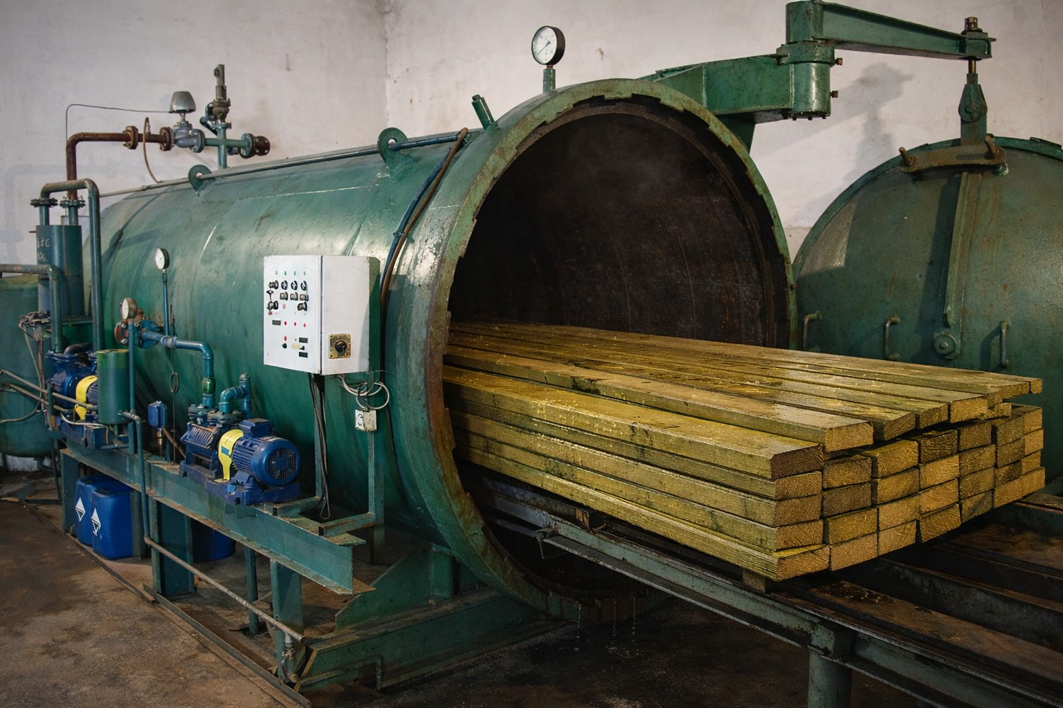 Otwarty autoklaw z którego wyjeżdża zaimpregnowane drewno