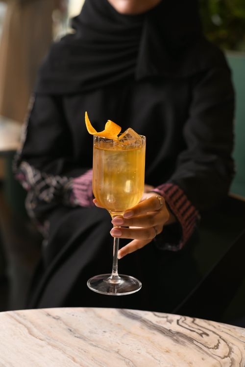 Close up of a bar tenders mixing a blue herbal drink