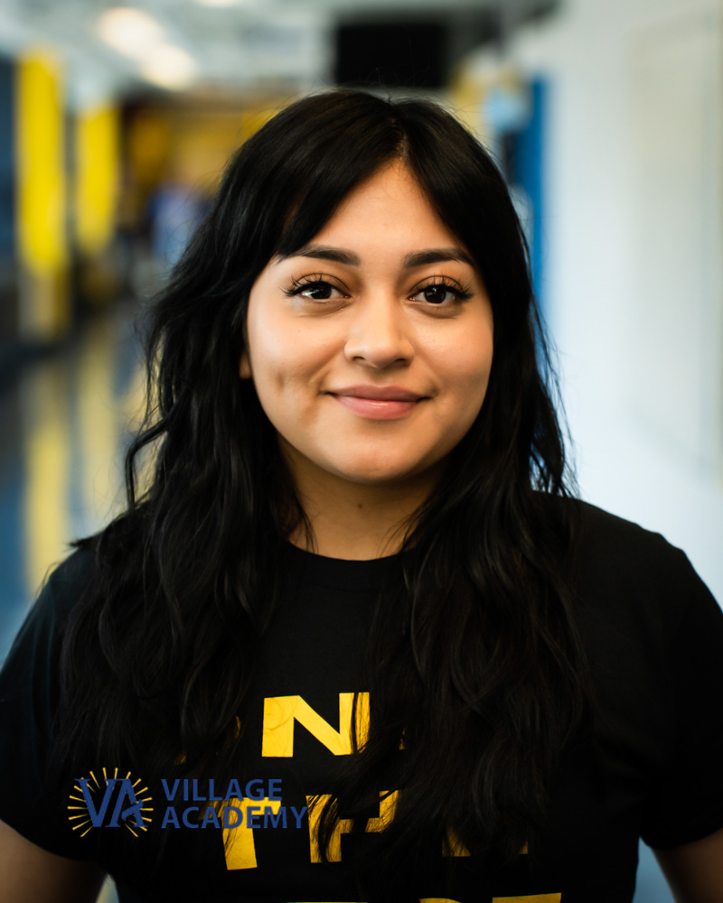 Ms. Muicela smiling in a Village Academy school hallway