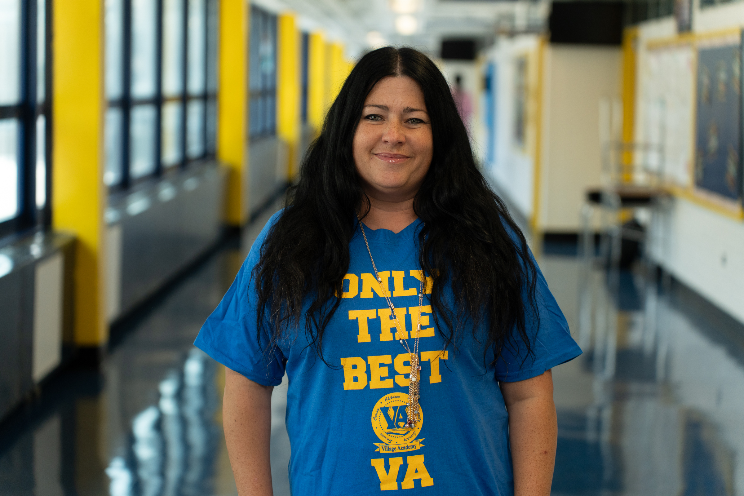 Ms. Ansaldi smiling in Village Academy school hallway