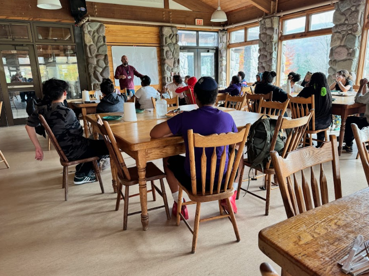 Students listen to an instructor during an outdoor education retreat session