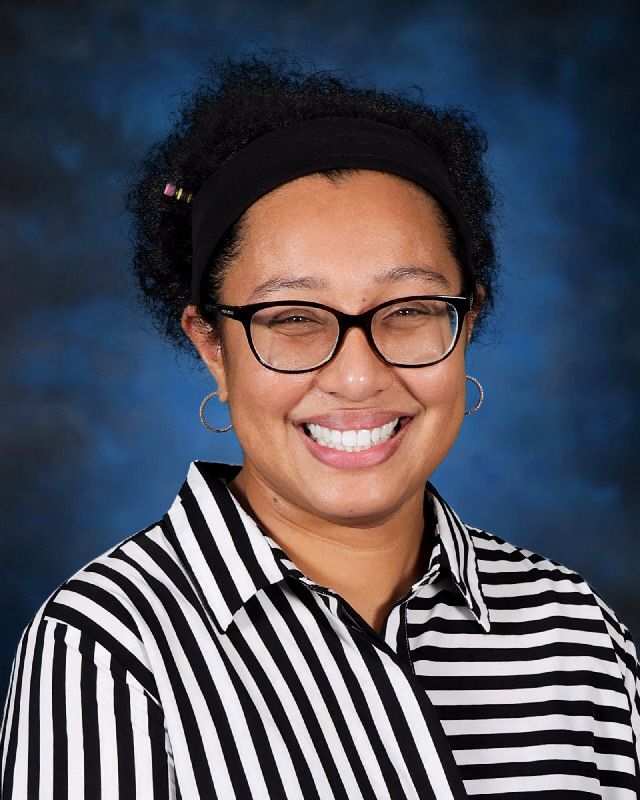 Ms. Naidoo smiling in a school staff portrait photo