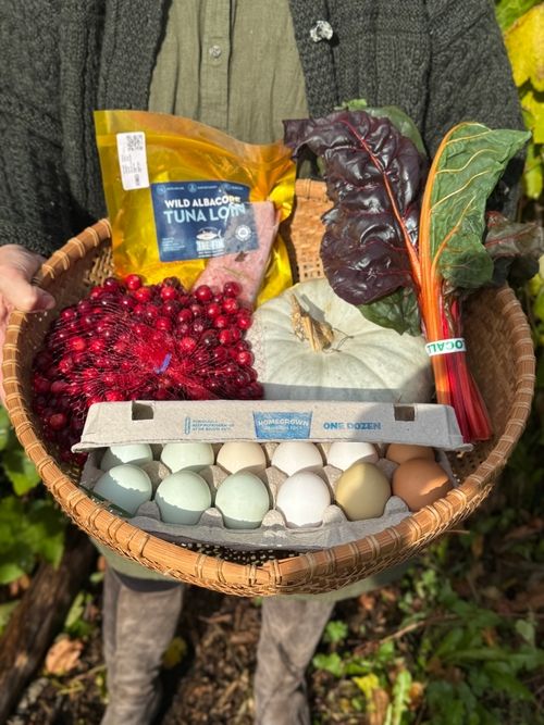 A Neighbor's Garden basket with farm eggs, wild albacore tuna, cranberries, rainbow chard, and squash
