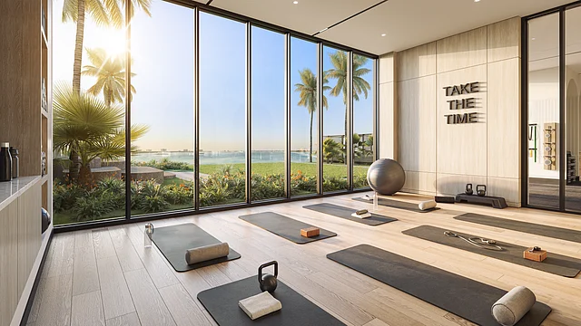 Ocean-view yoga room with floor-to-ceiling windows and palm trees