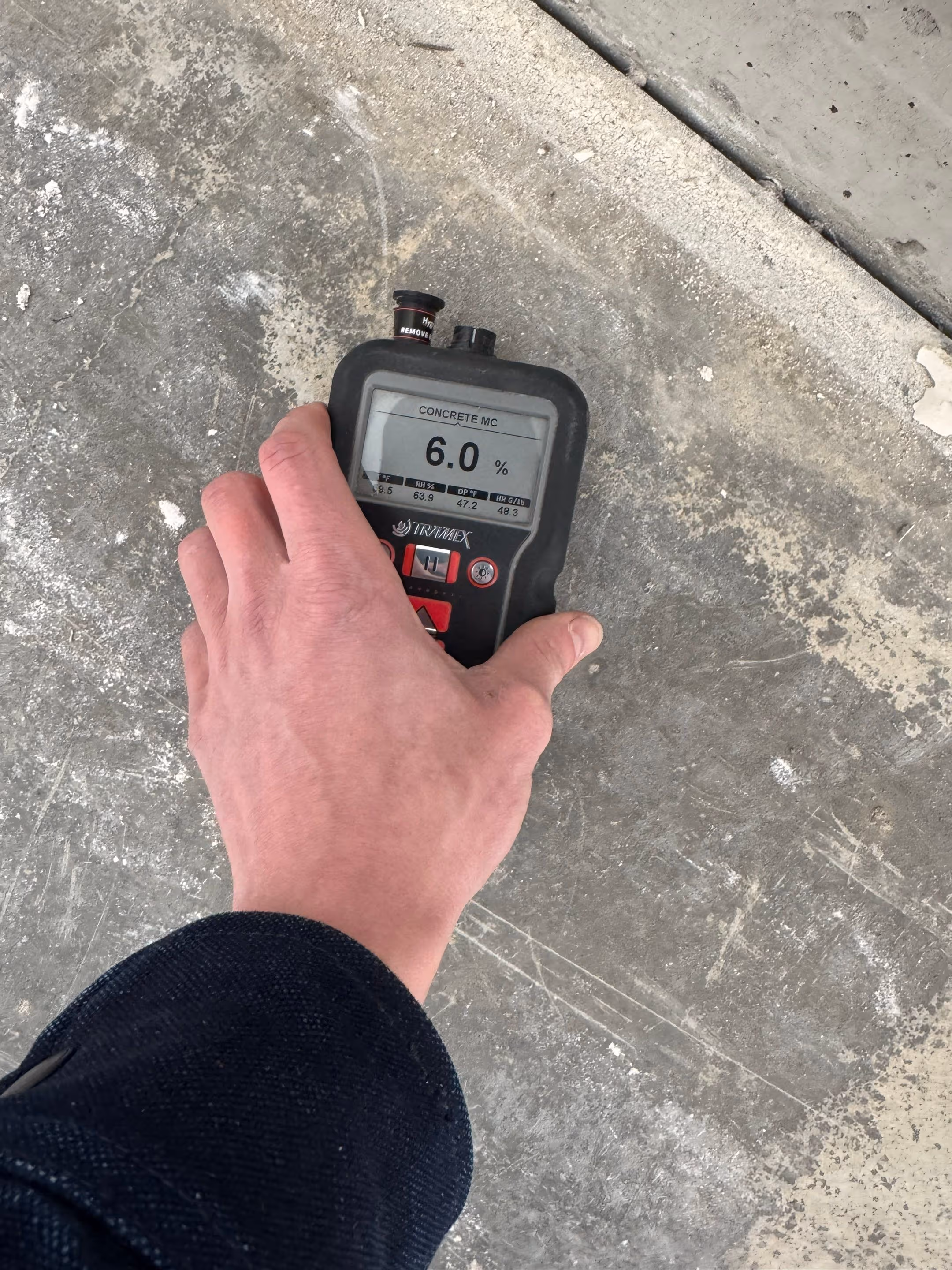 Tramex concrete moisture meter reading 6.0% on a bare concrete slab before Penntek polyurea floor coating installation in Langley, WA