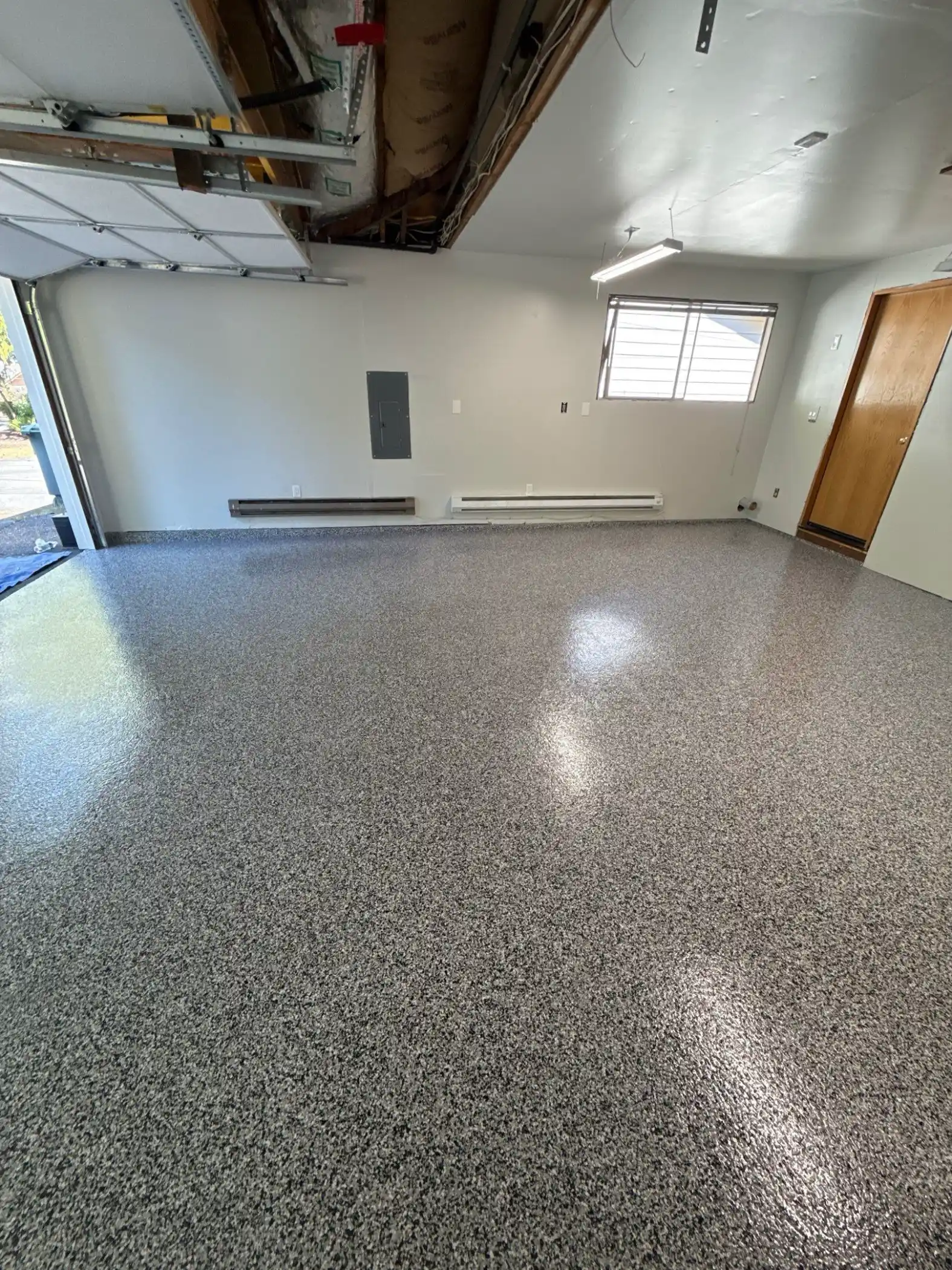 Domino flake polyurea garage floor in an empty Edmonds garage with a side window