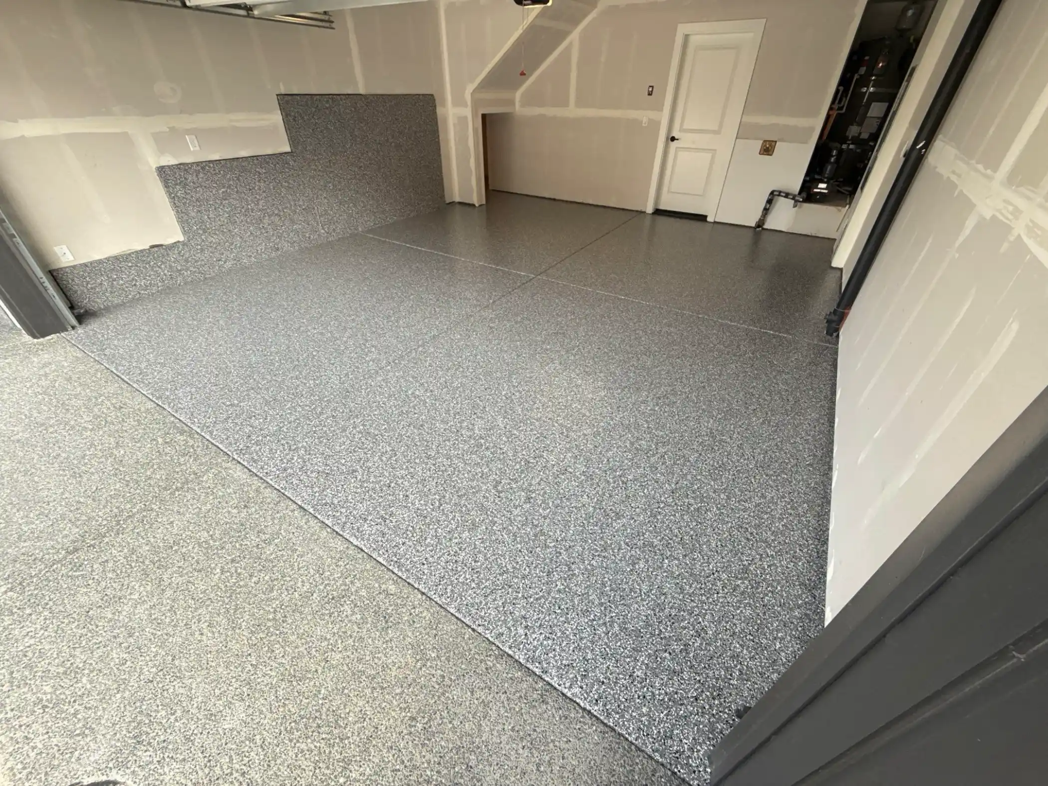 Smoke flake polyurea garage floor with a coated concrete stem wall in North Bend
