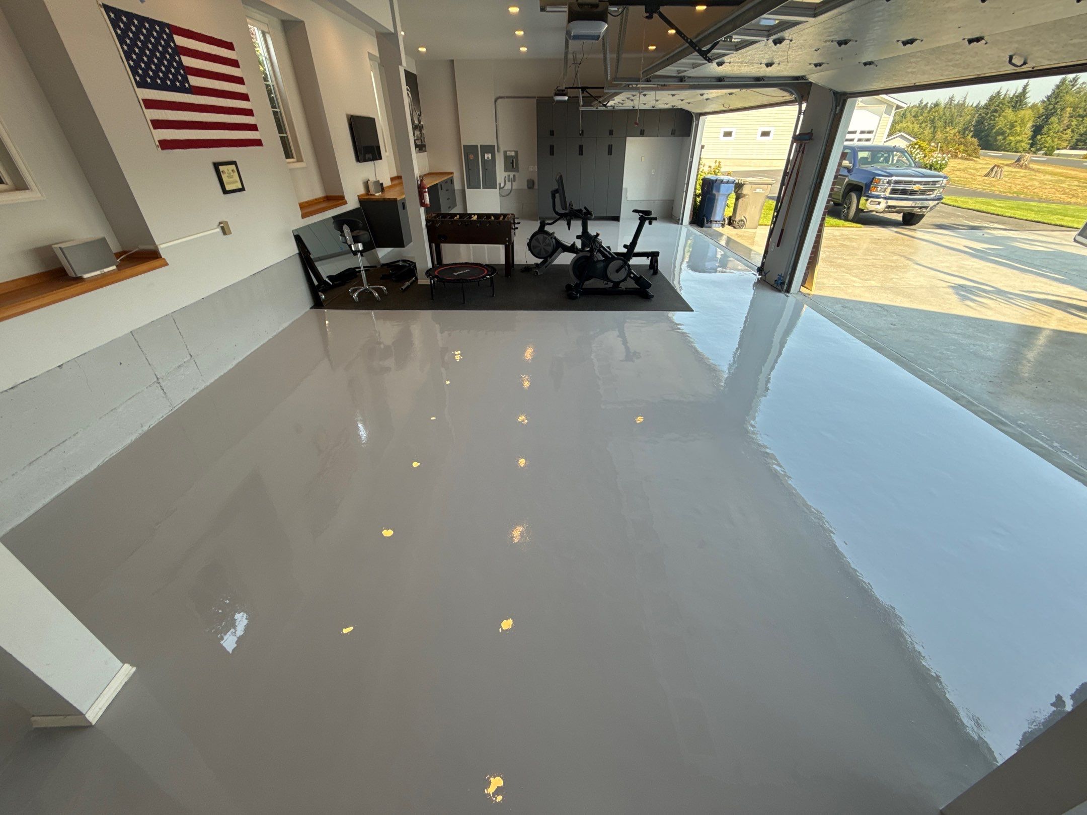 Lake Stevens garage gym and office with solid grey polyurea floor and flag