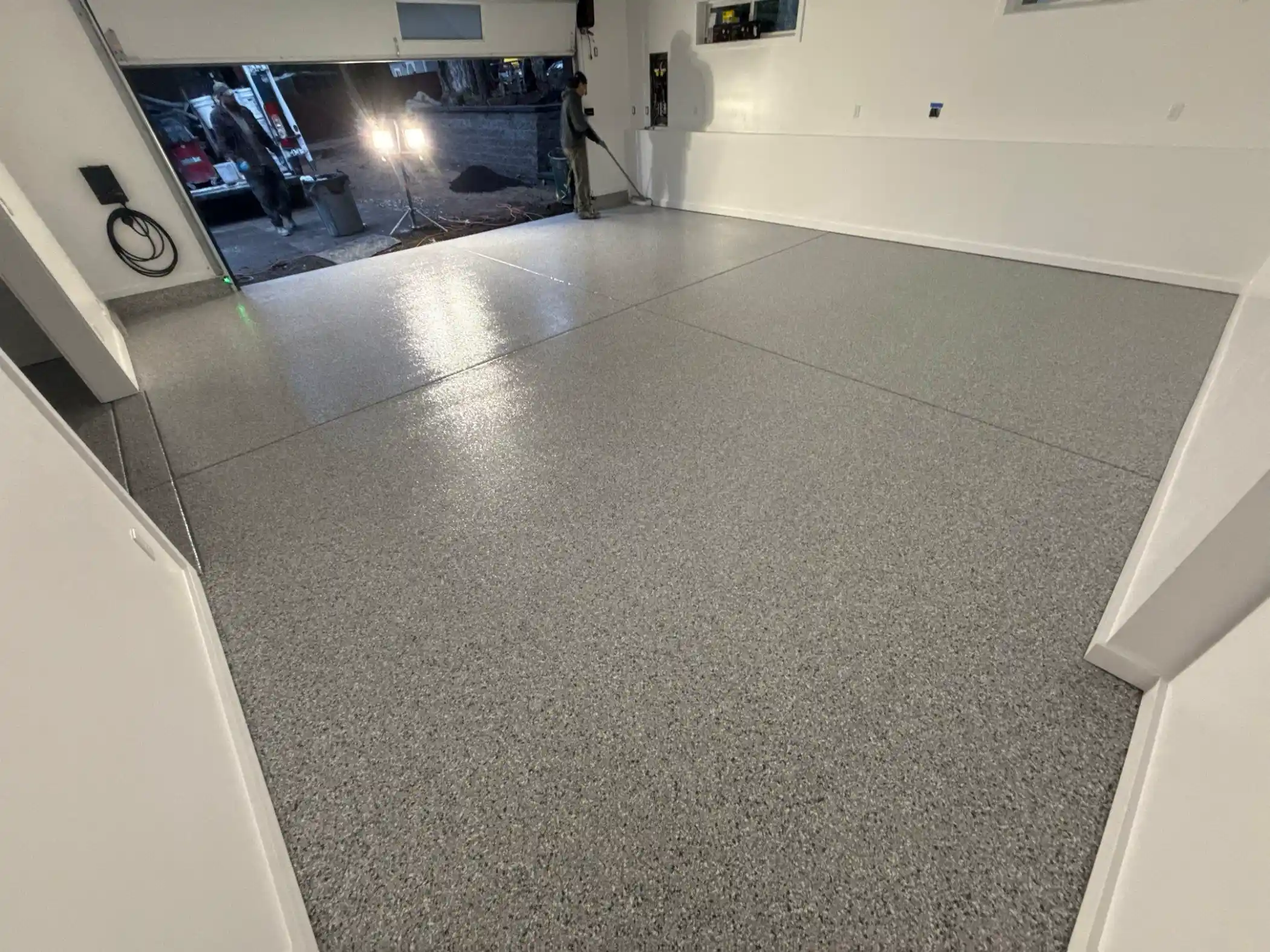 Glossy Tidal Wave polyurea garage floor under work lights at the open door in Woodinville