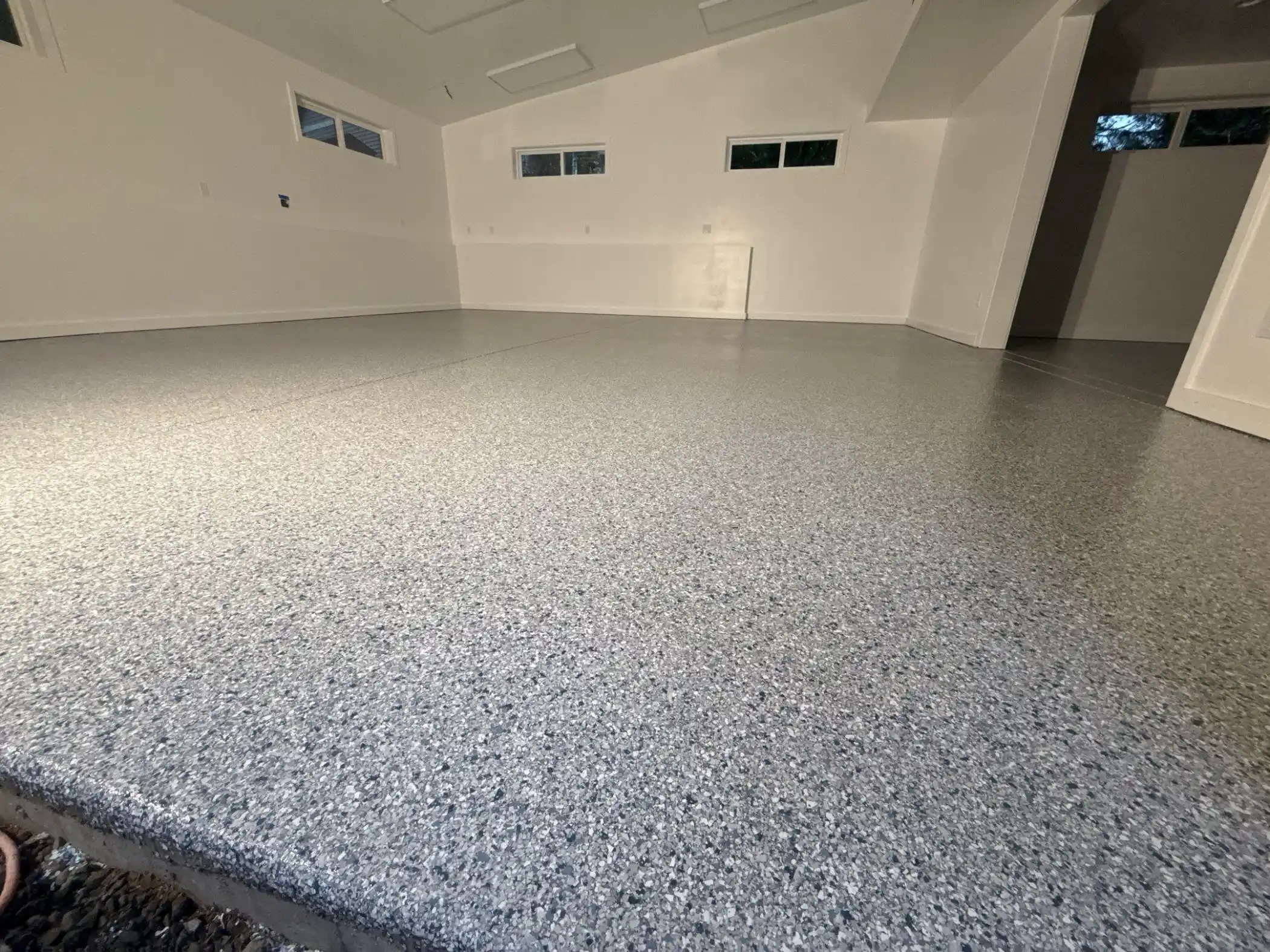 Close view of white, gray and navy Tidal Wave flake on a garage floor