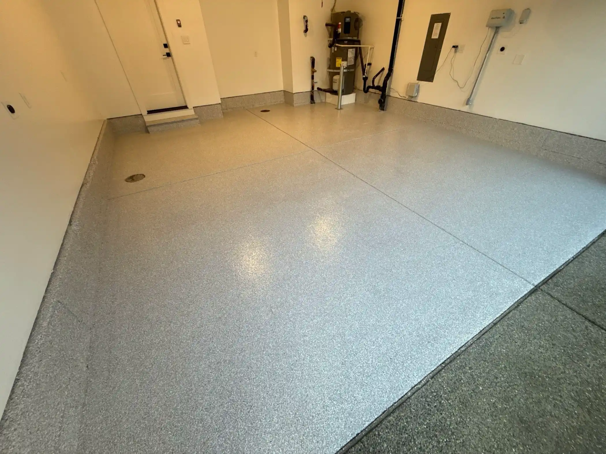 Ash flake polyurea floor with water heater and pipes in a Duvall garage