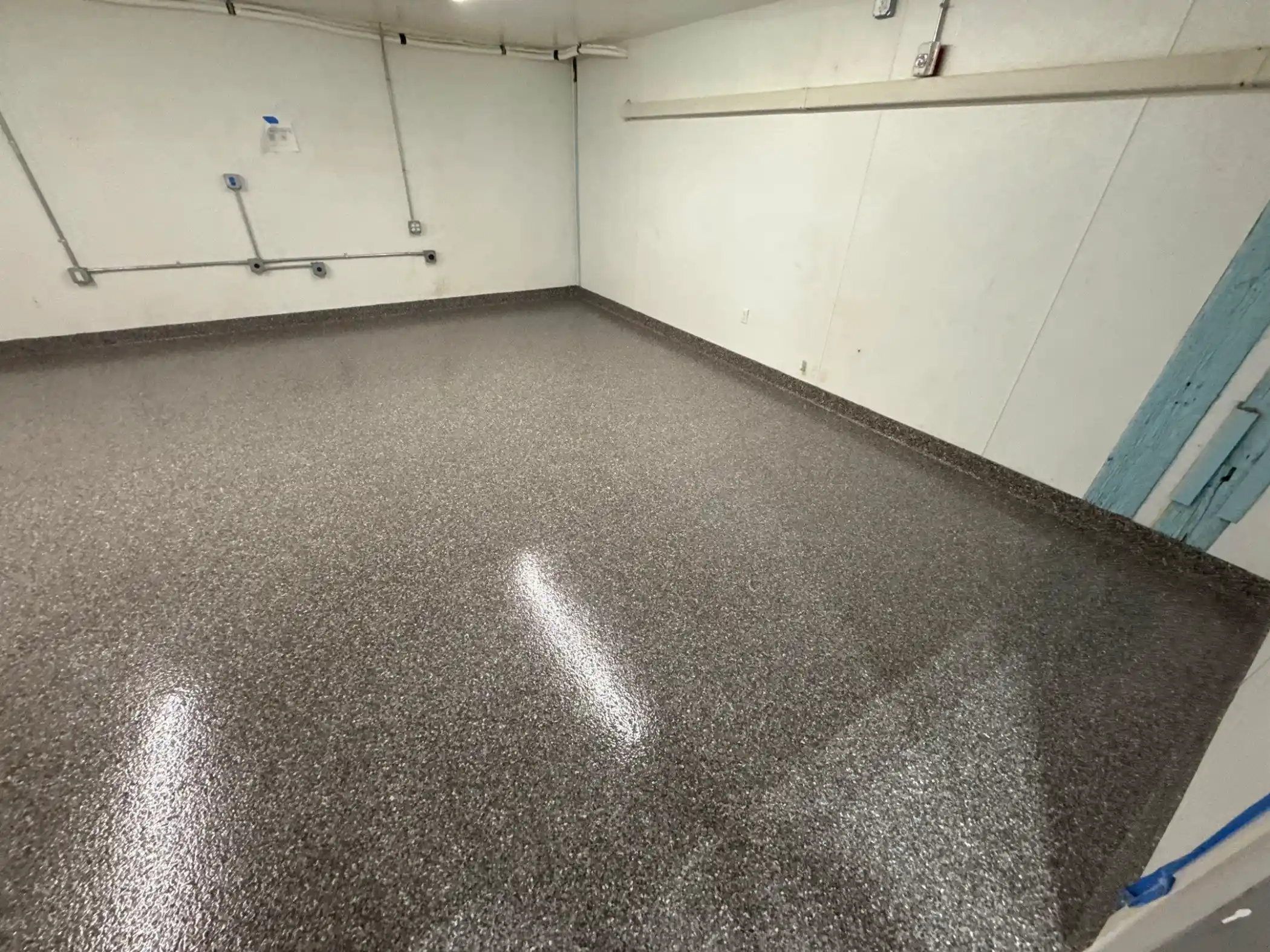 Seattle warehouse room with Silver Creek Penntek polyurea floor and conduit on walls