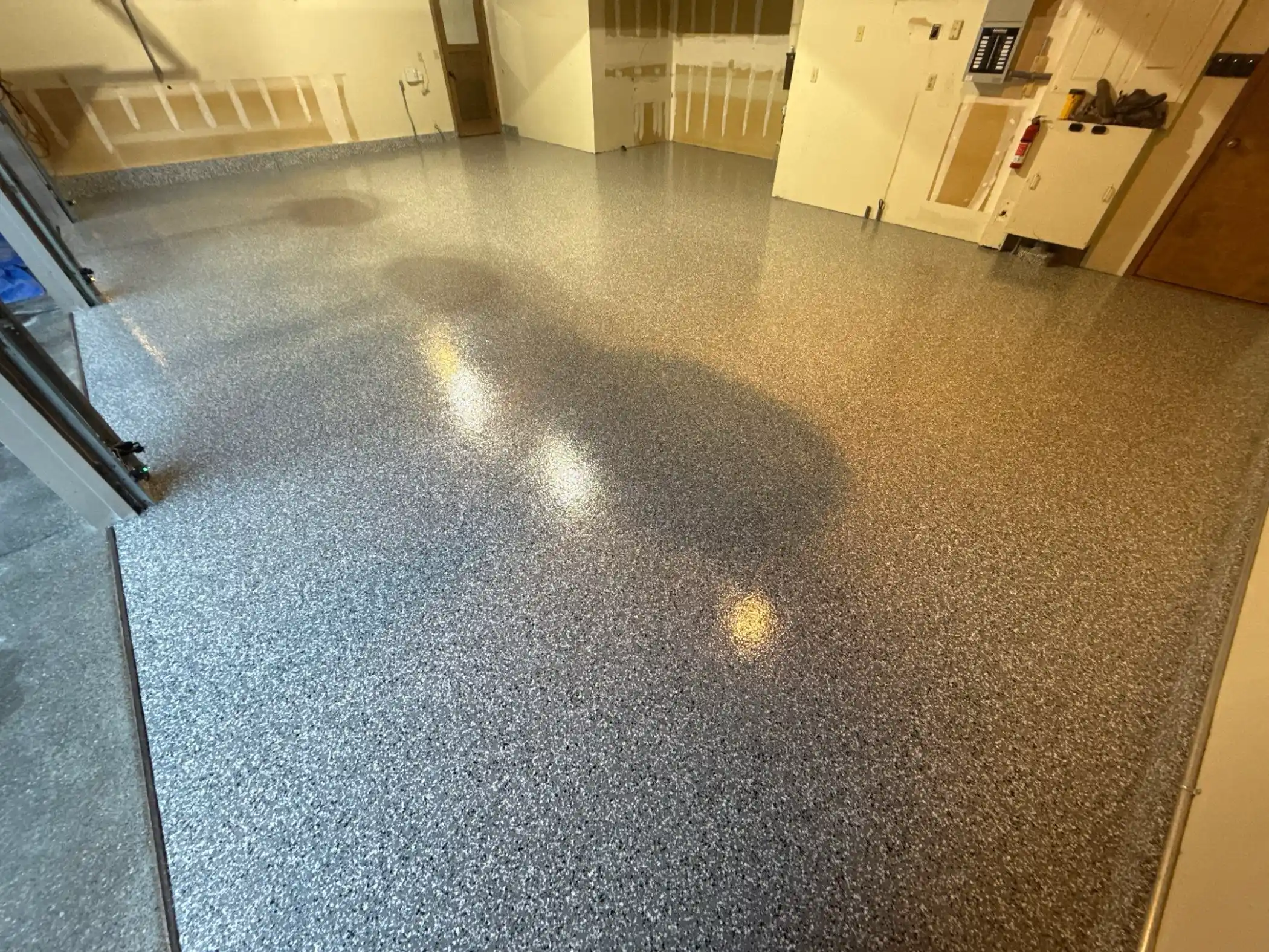 Glossy Smoke flake polyurea floor in a large Edmonds garage with three bay doors