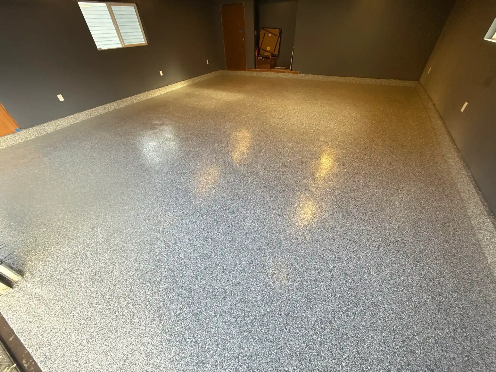 Glossy Slate Stone garage floor with a coated edge curb in a Camano Island home