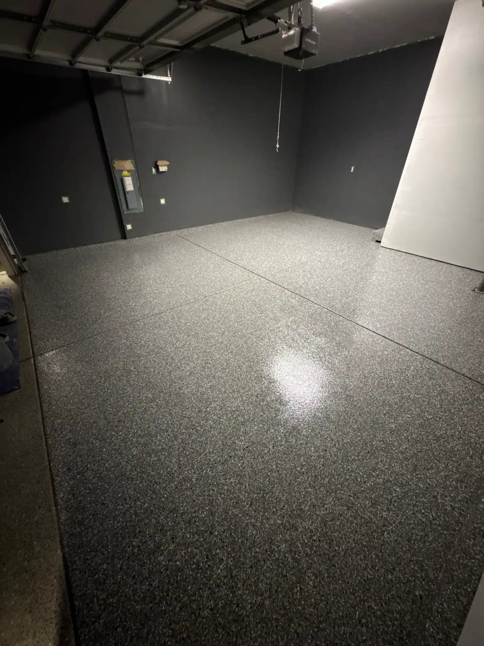 Glossy Smoke polyurea floor against dark grey painted walls in a Bothell garage