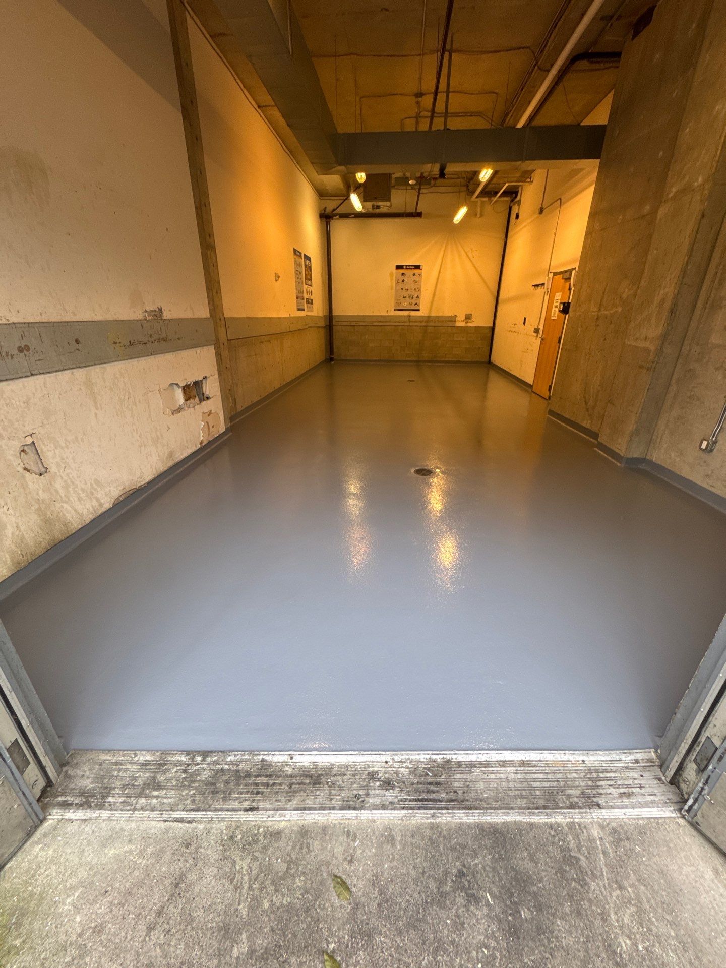 Solid gray polyurea floor in a Seattle apartment building trash room