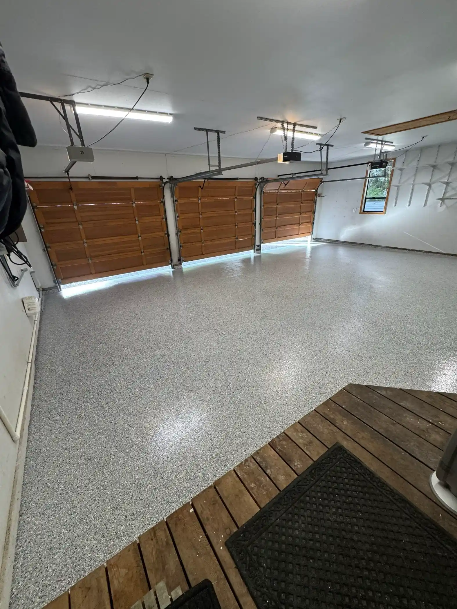 Three-car Fox Island garage with cedar doors and Tidal Wave flake floor