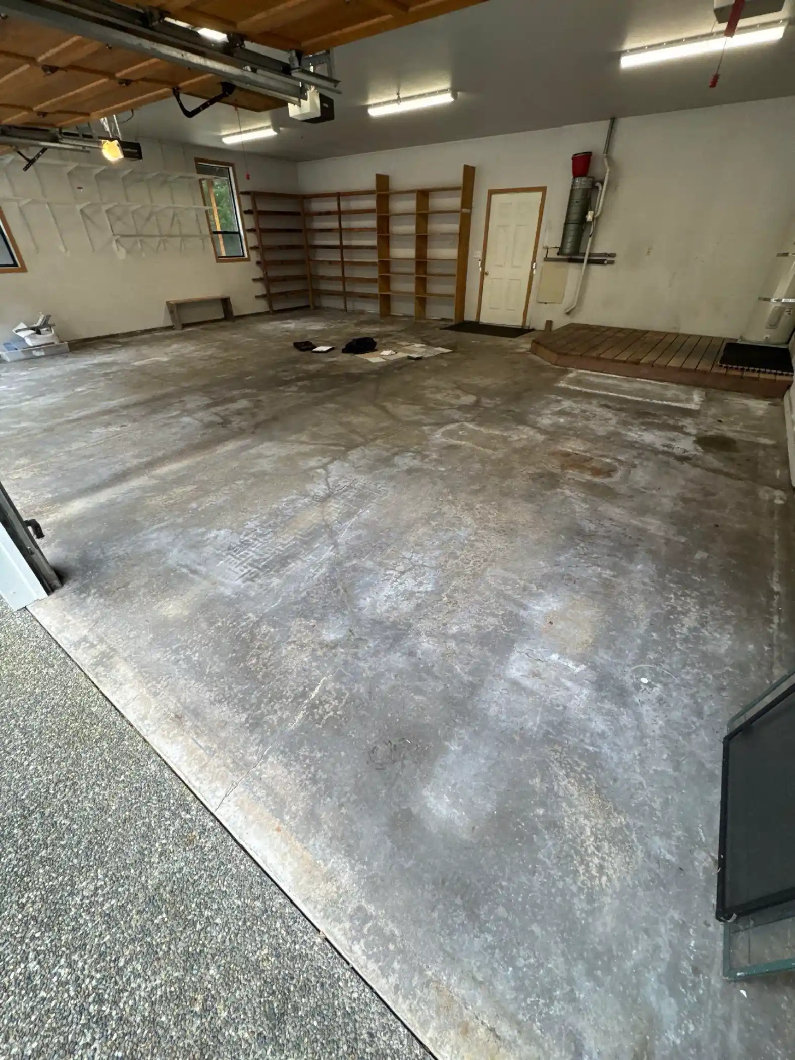 Stained bare concrete in a Fox Island garage before polyurea coating