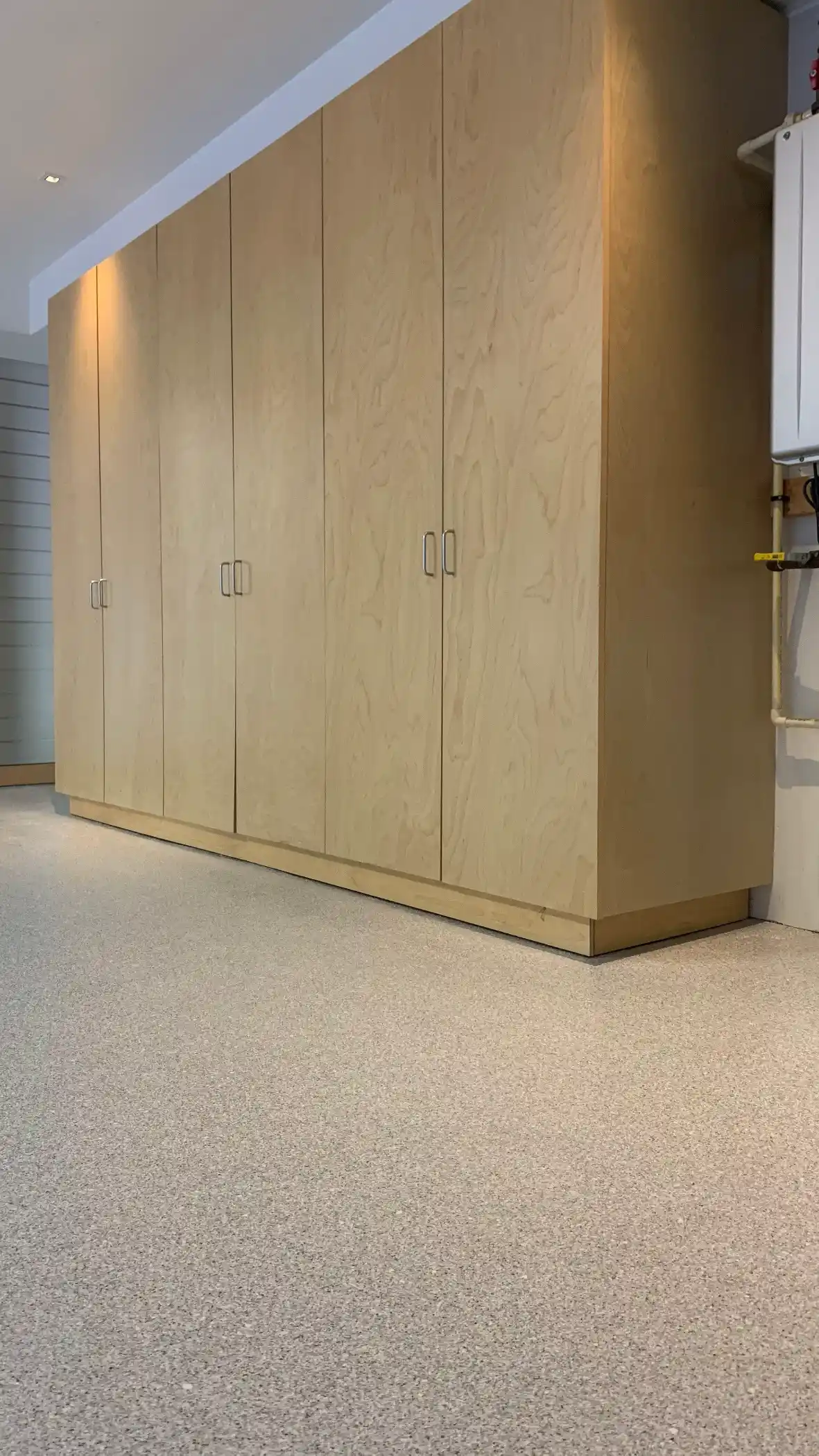 Tall maple garage cabinets on a light Limestone Penntek floor in Hunts Point