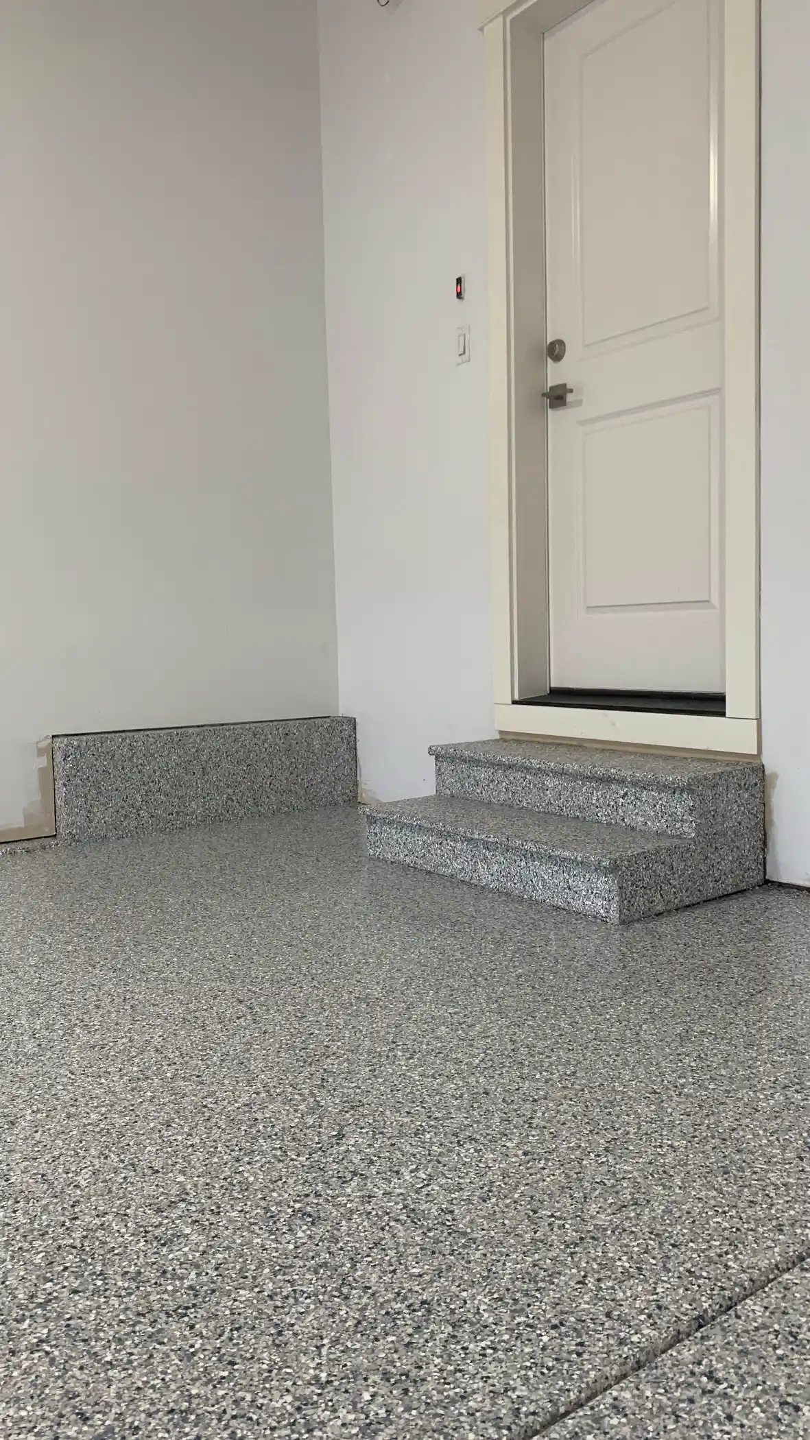 Two entry steps coated in Tidal Wave flake leading to the house door in Sammamish