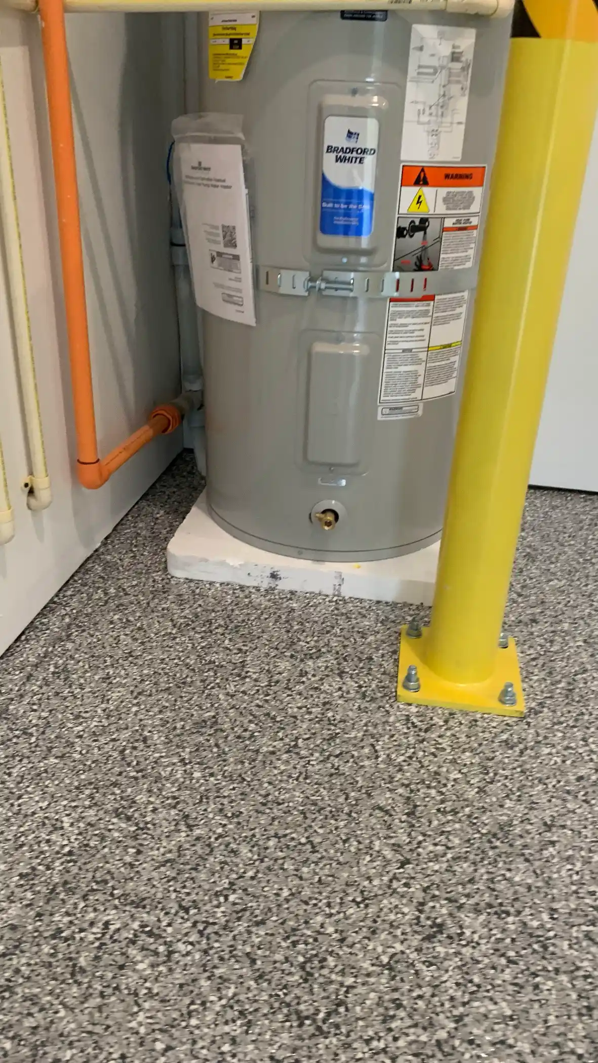 Slate Stone flake floor around a water heater and yellow bollard in a Shoreline garage