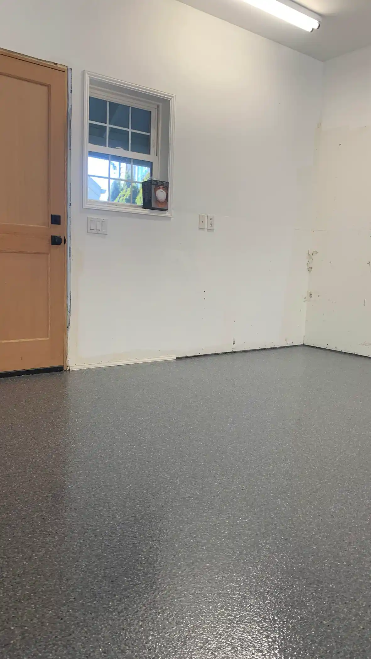 Lani Grey flake floor in the corner of a Belfair garage by a wood door
