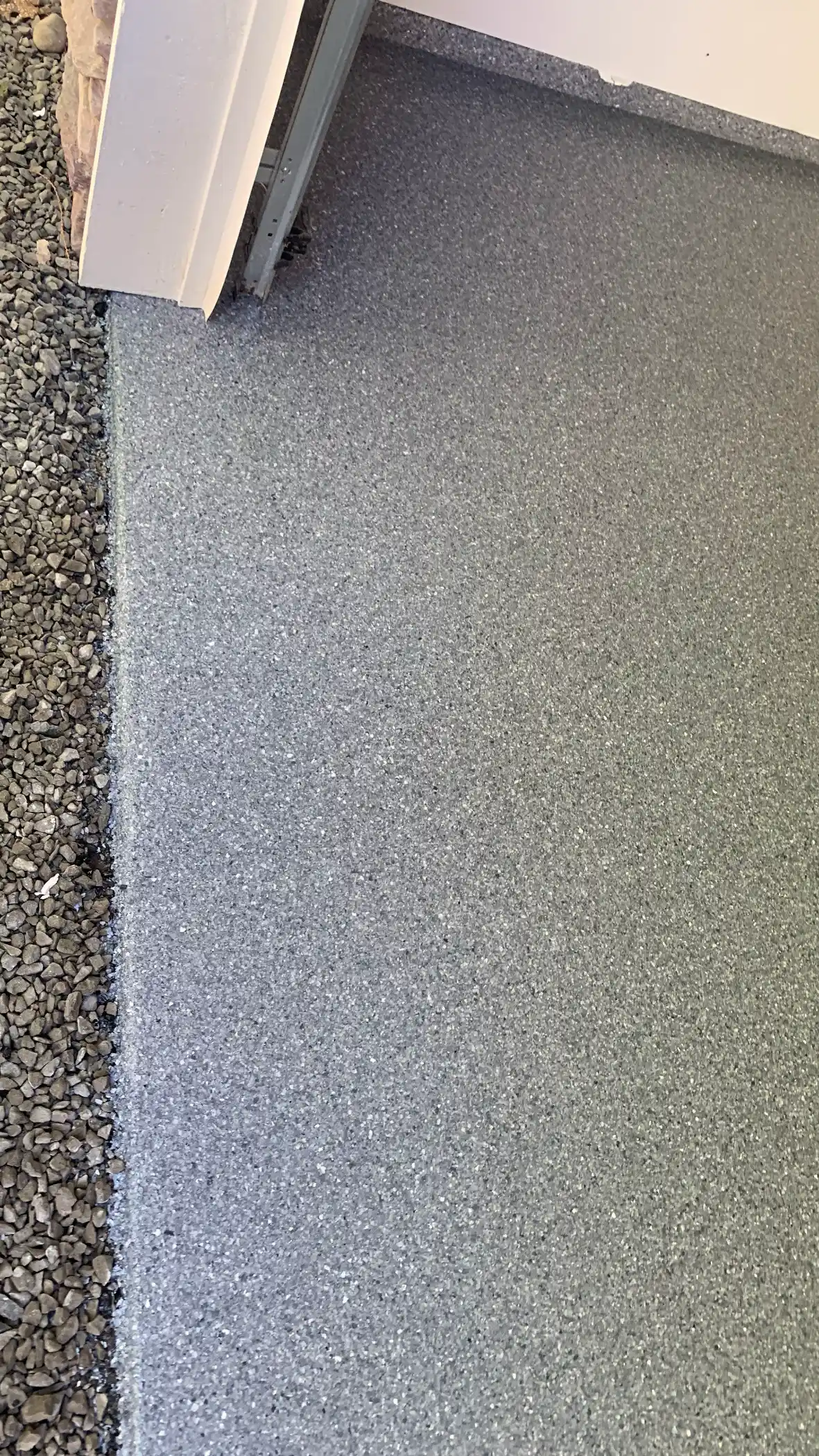 Edge of a Lani Grey polyurea floor at the garage door line in Belfair