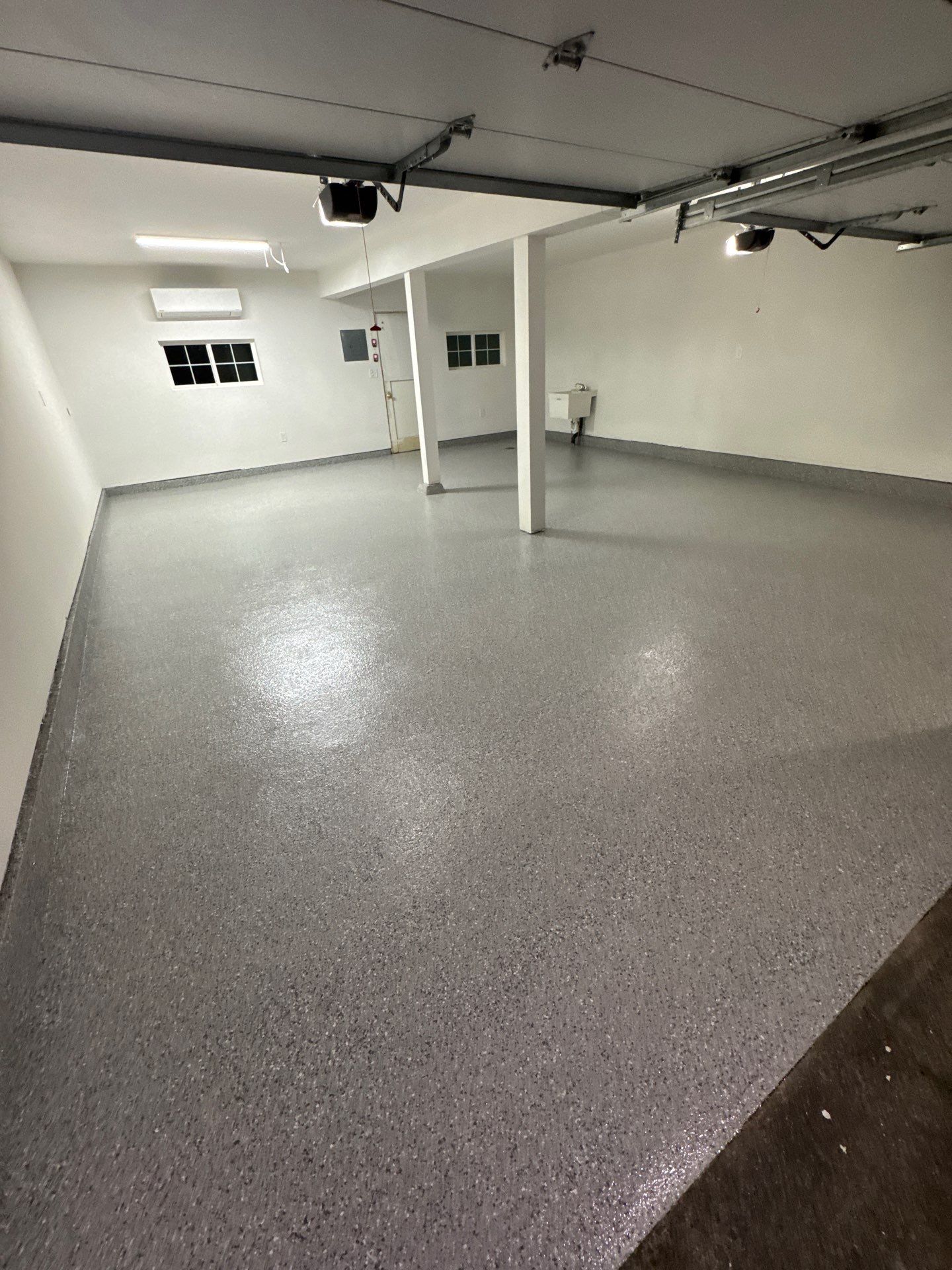 Husky gray flake polyurea garage floor with support posts in a Seattle home