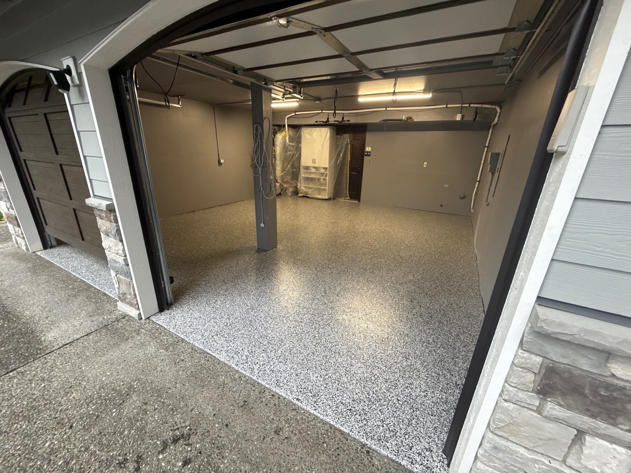Domino flake polyurea garage floor seen through the open door of a North Bend home