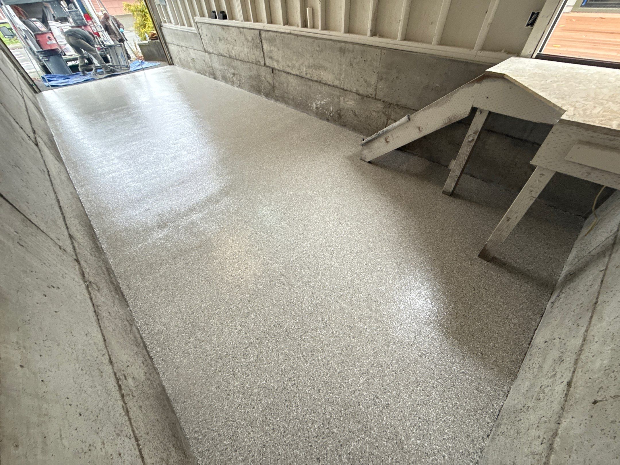 Mount Everest flake floor in a long narrow Issaquah garage with concrete walls and wood stairs