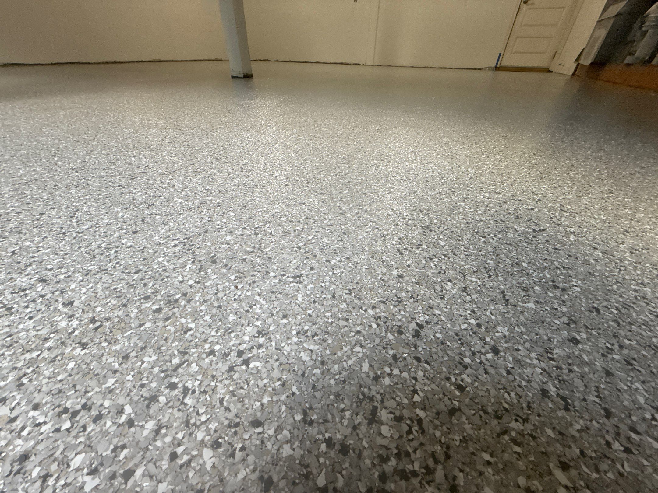 Close view of white, gray and tan Mount Everest flake on a Woodinville garage floor