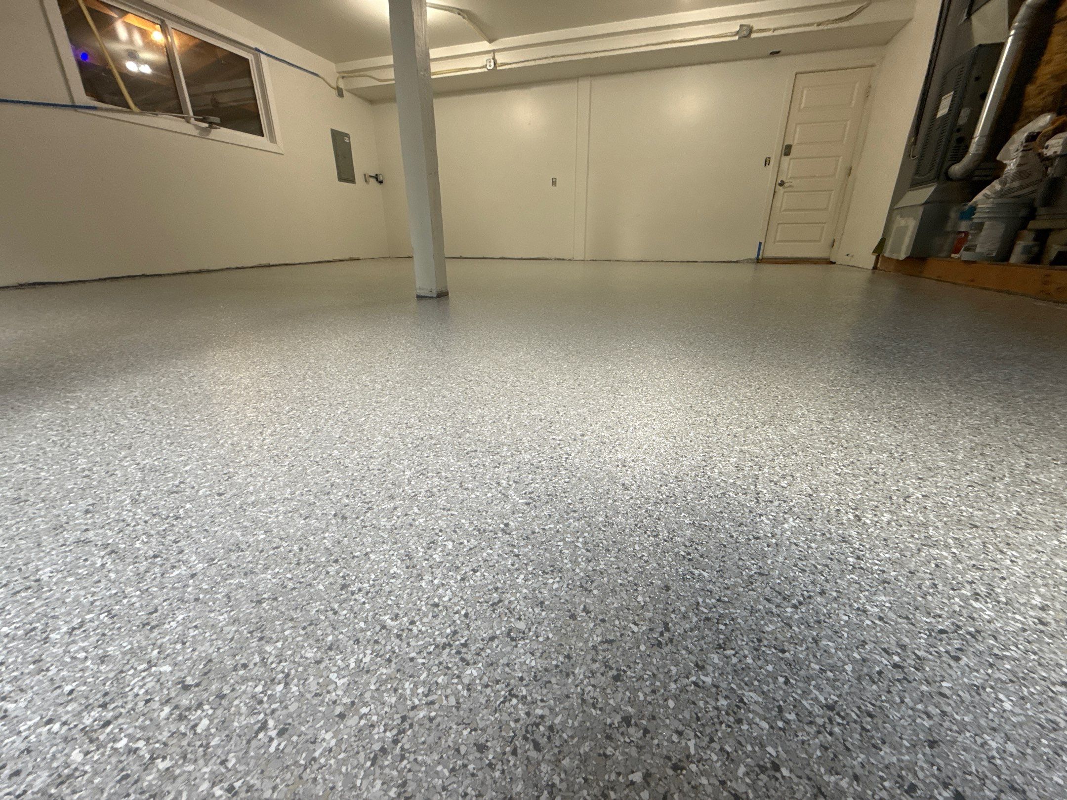 Low angle across a finished Mount Everest polyurea garage floor with white walls in Woodinville
