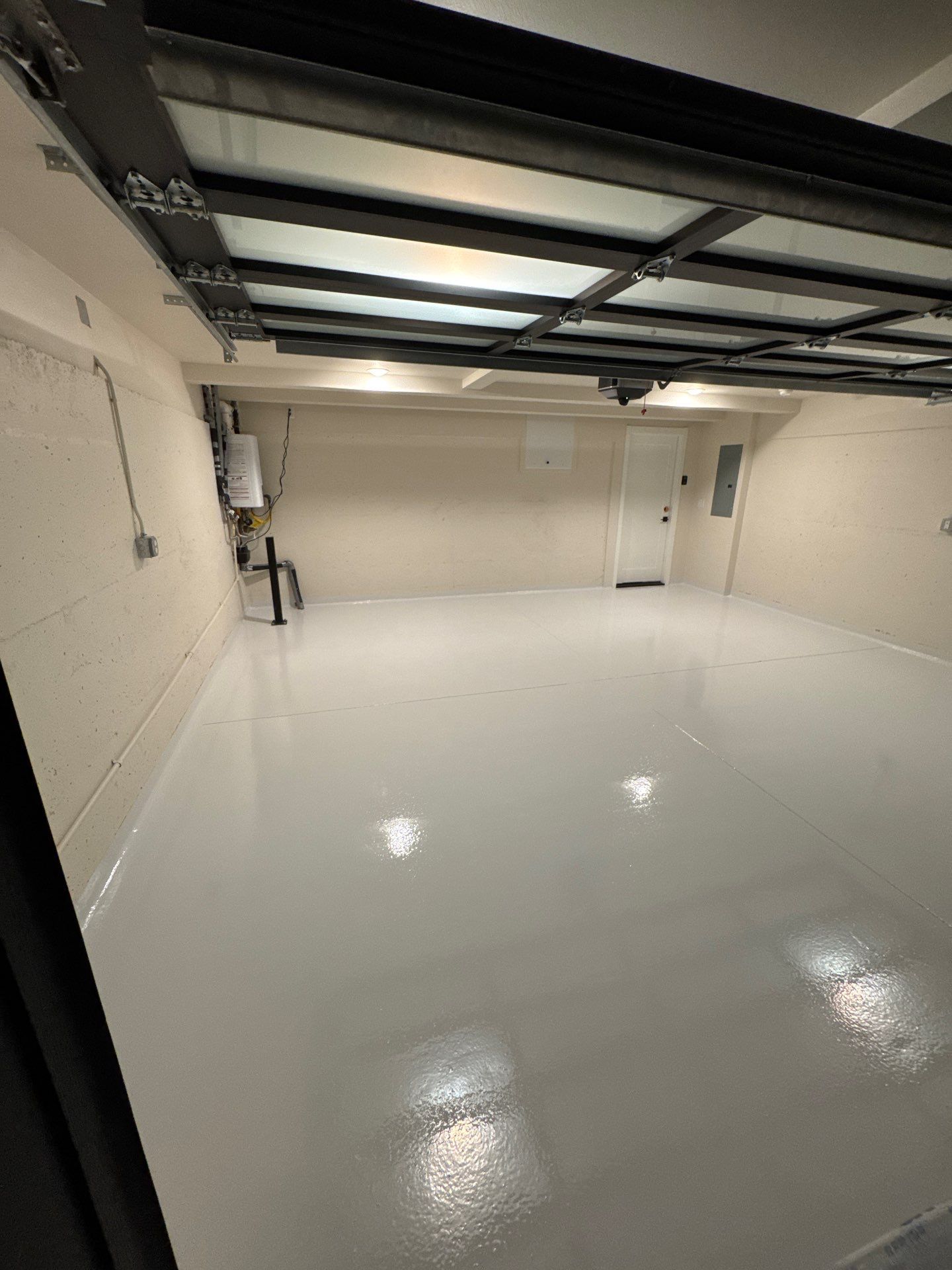 Solid Olympus White polyurea garage floor under a glass panel door in Seattle