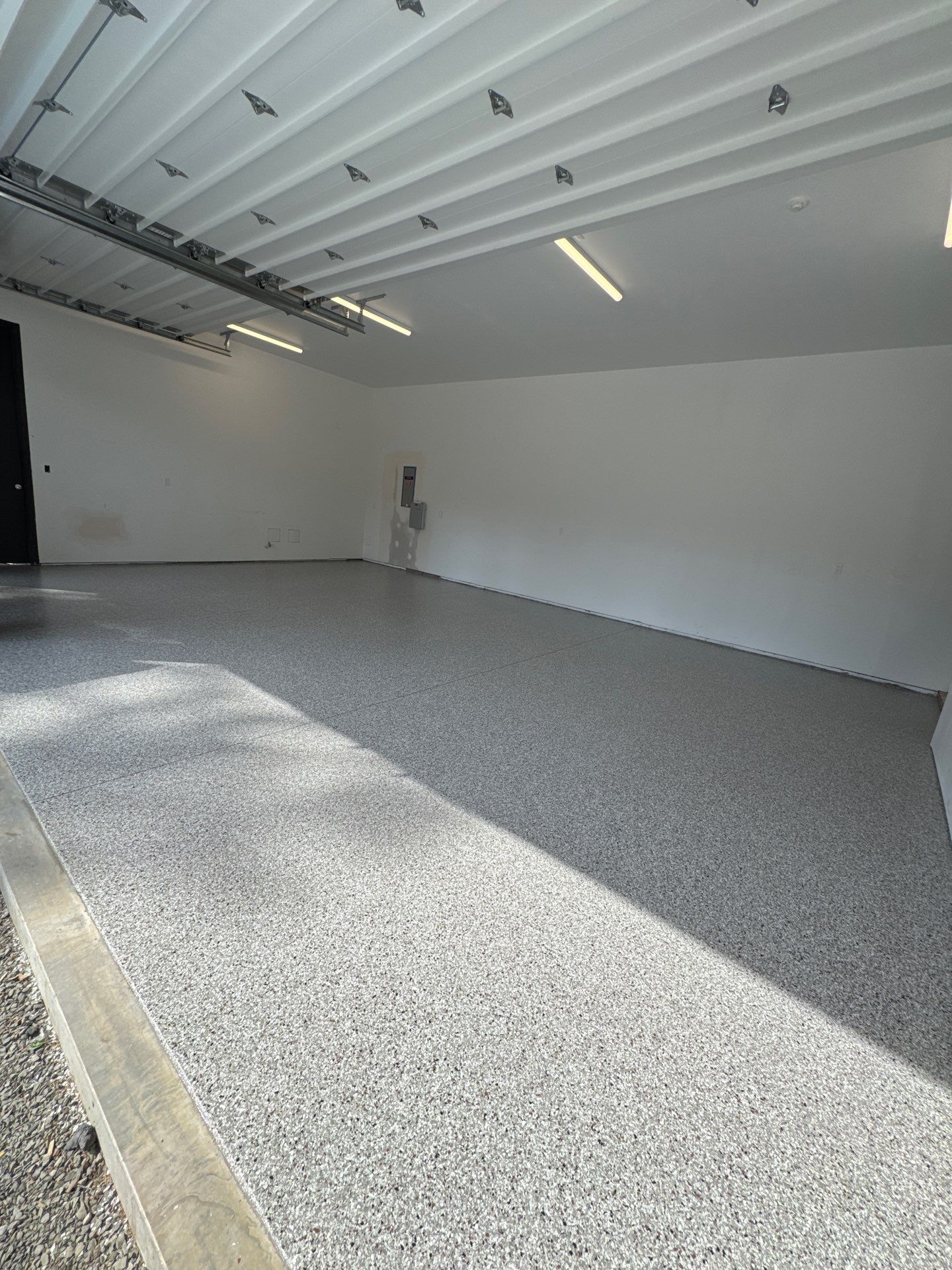 Finished Coyote flake garage floor with sun through the open door in Bellevue