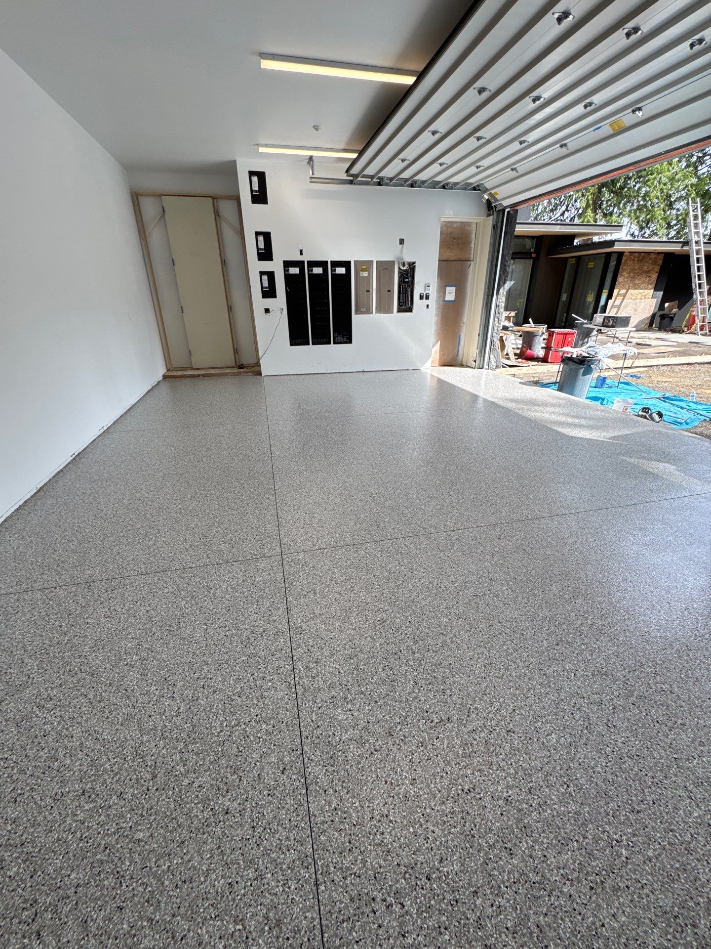 Coyote flake polyurea floor in a bright white remodeled garage in Bellevue