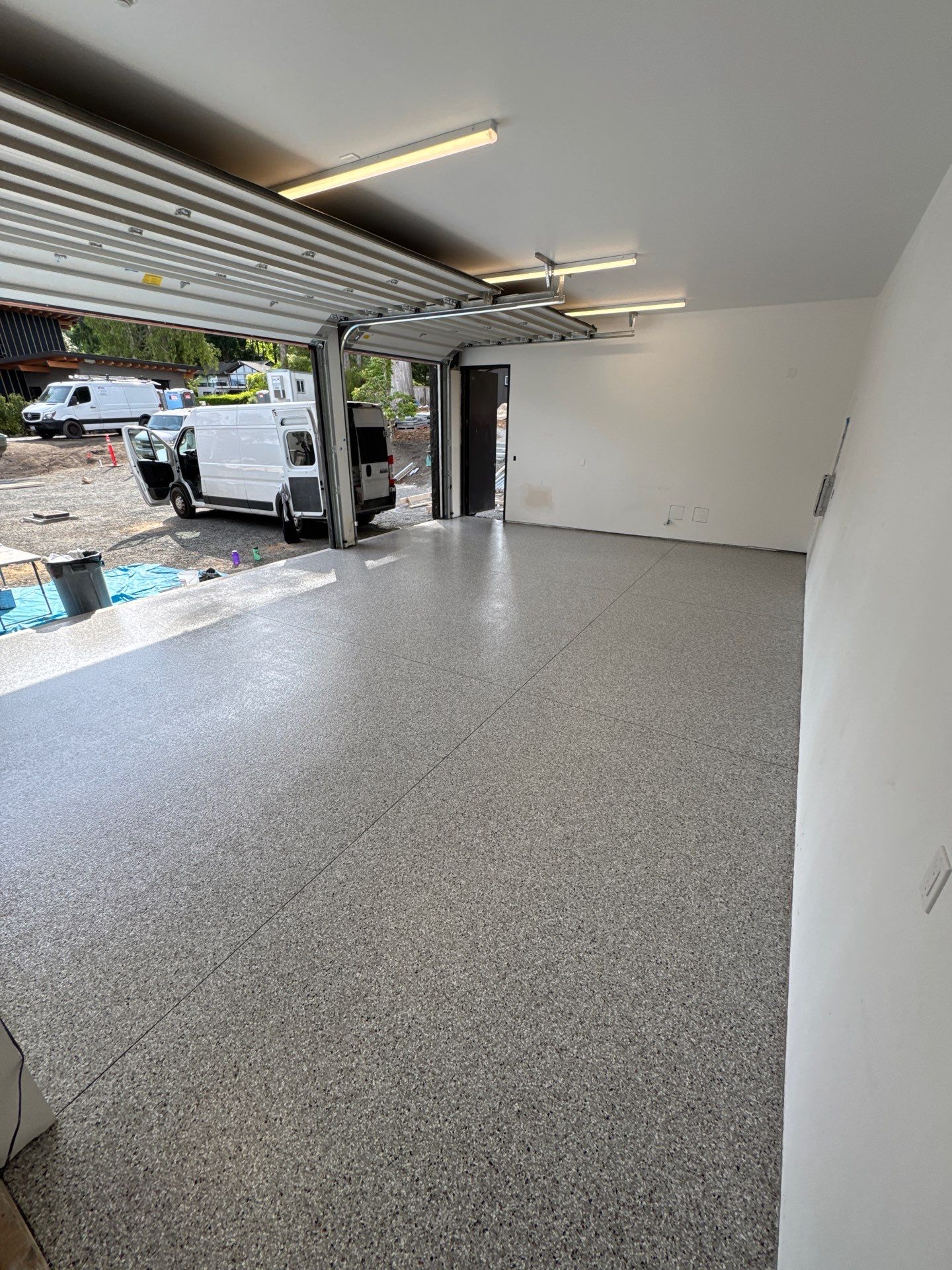 Coated Bellevue garage floor looking out the open door toward the driveway