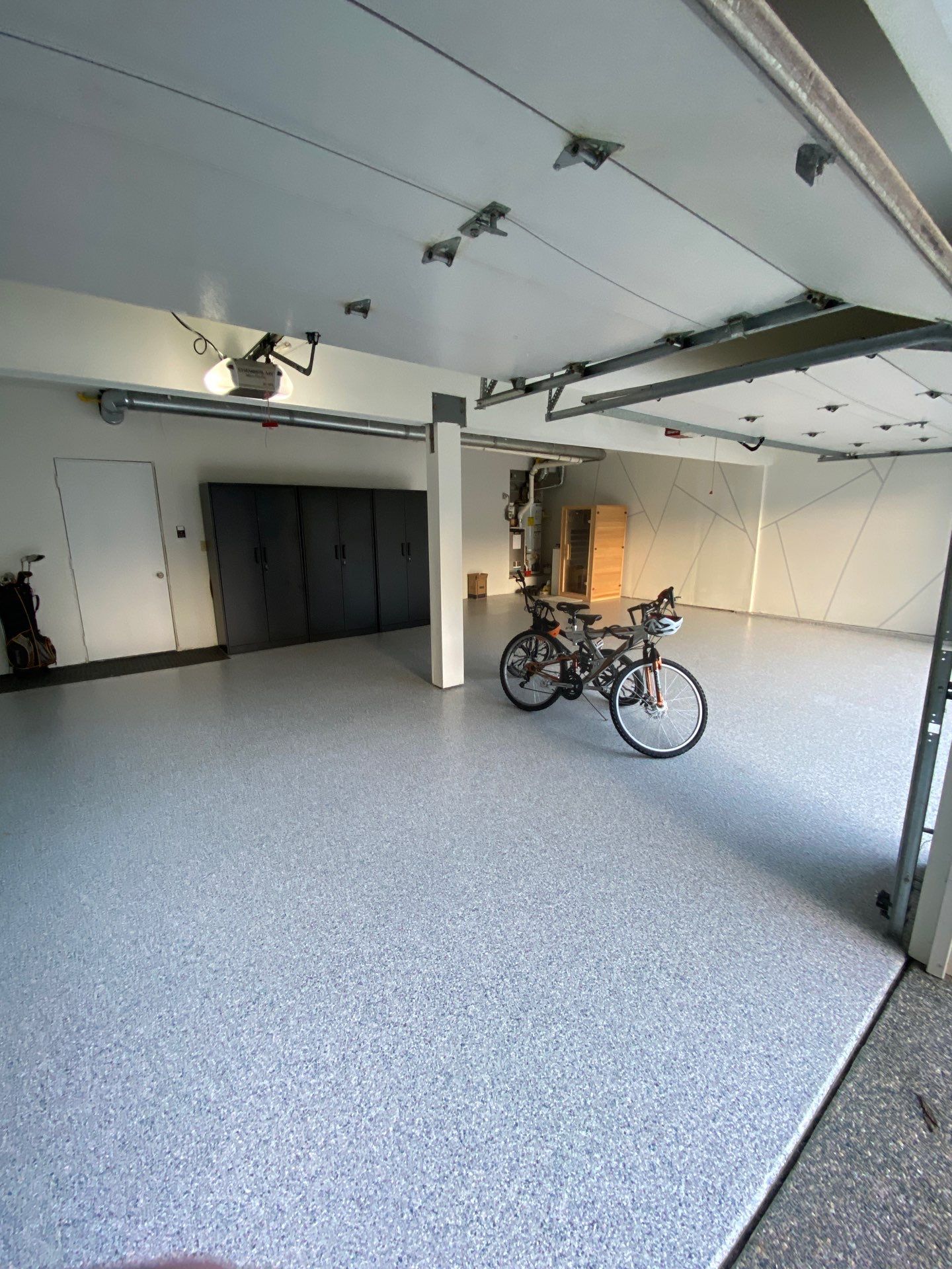 Tidal Wave flake polyurea garage floor with black cabinets and bike in a Snohomish home