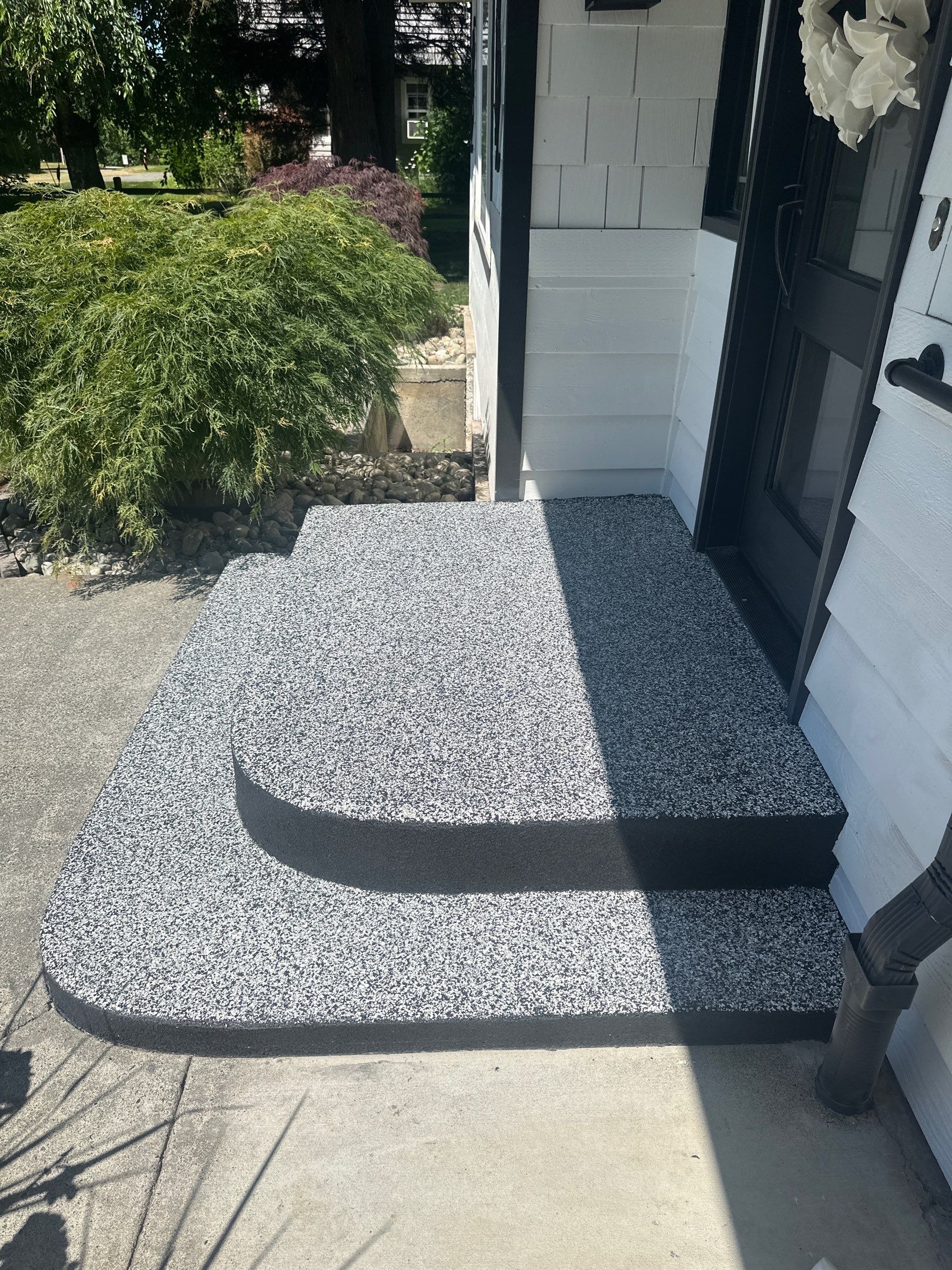 Side view of two rounded entry steps coated in Domino flake in Woodinville