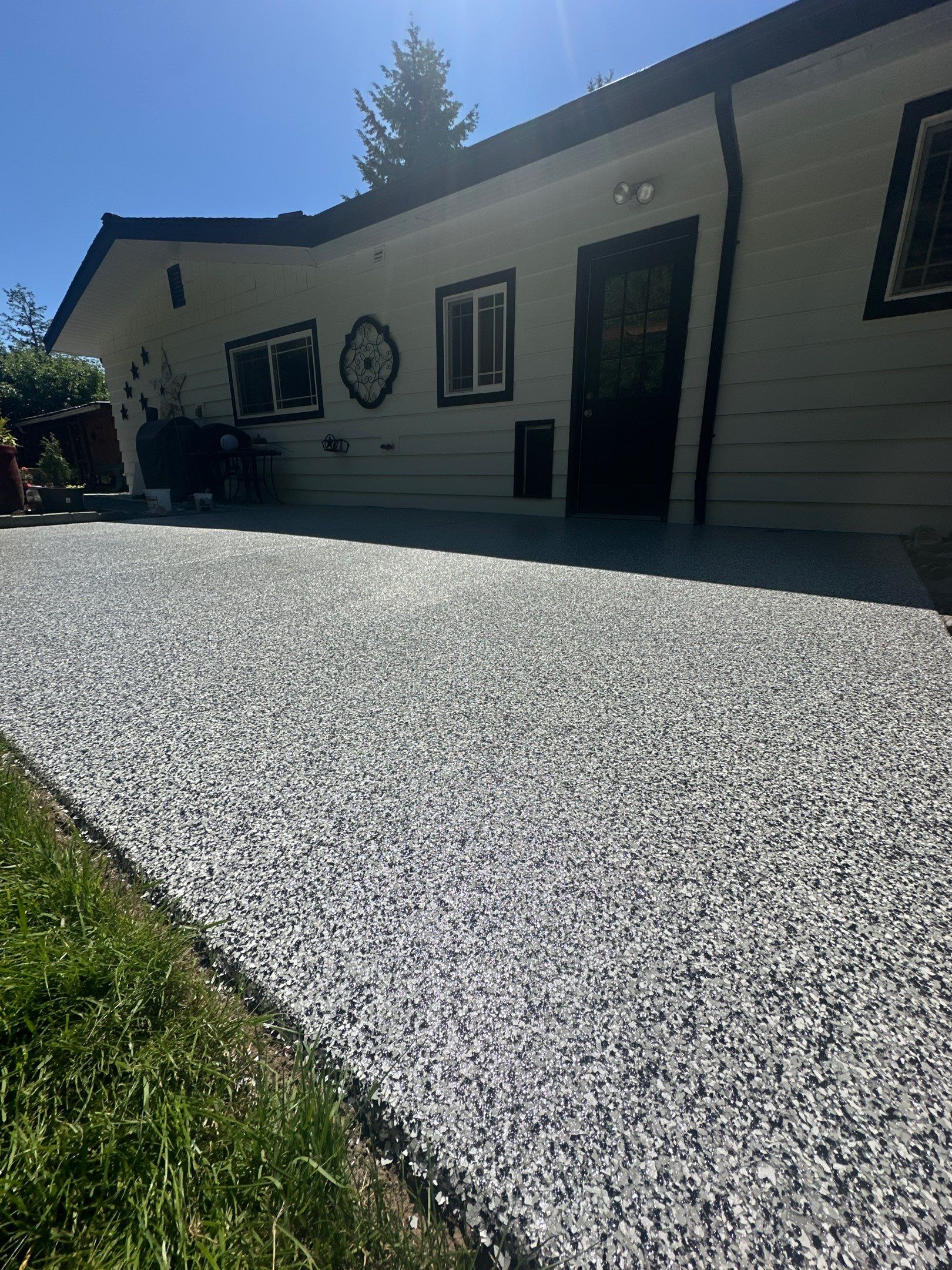 Close view of Domino flake on a coated front patio next to the lawn