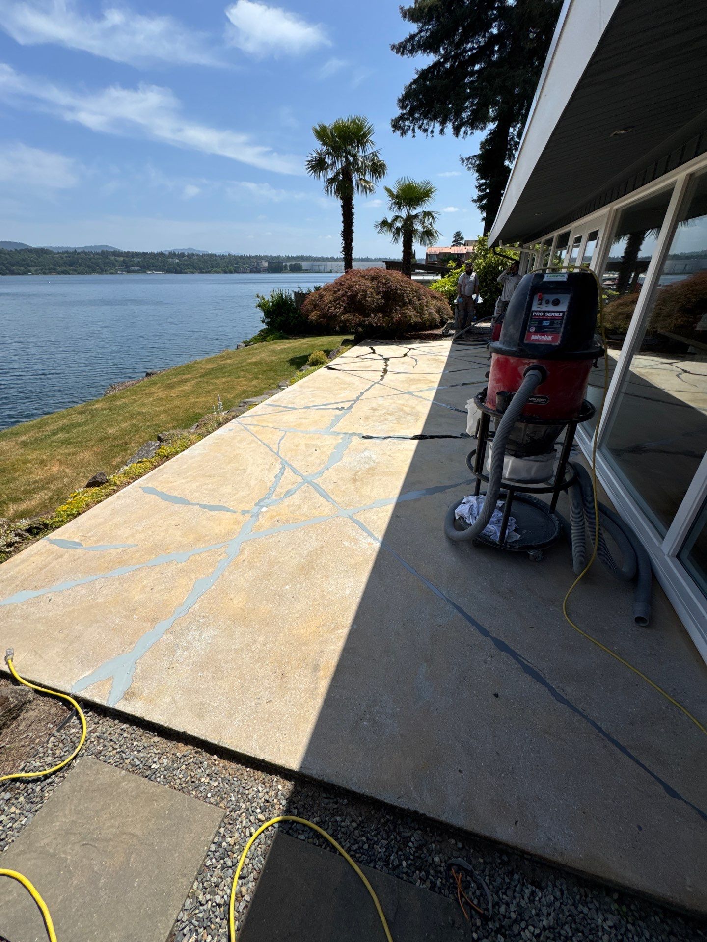 Cracked lakefront patio in Seattle ground and marked for crack repair before coating
