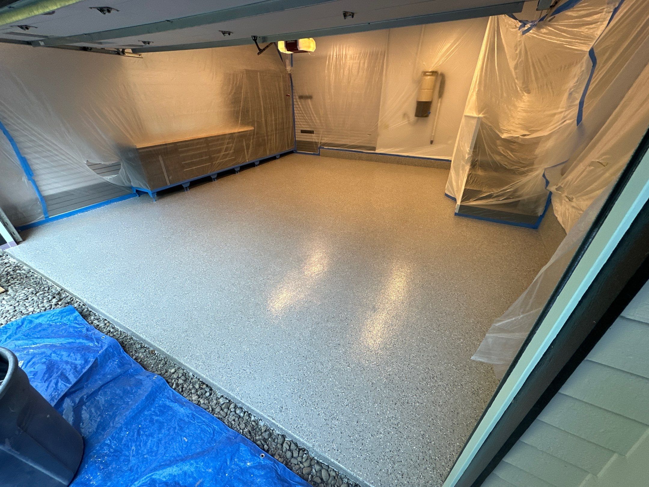 Polyurea flake garage floor with cabinets masked in plastic in an Issaquah garage