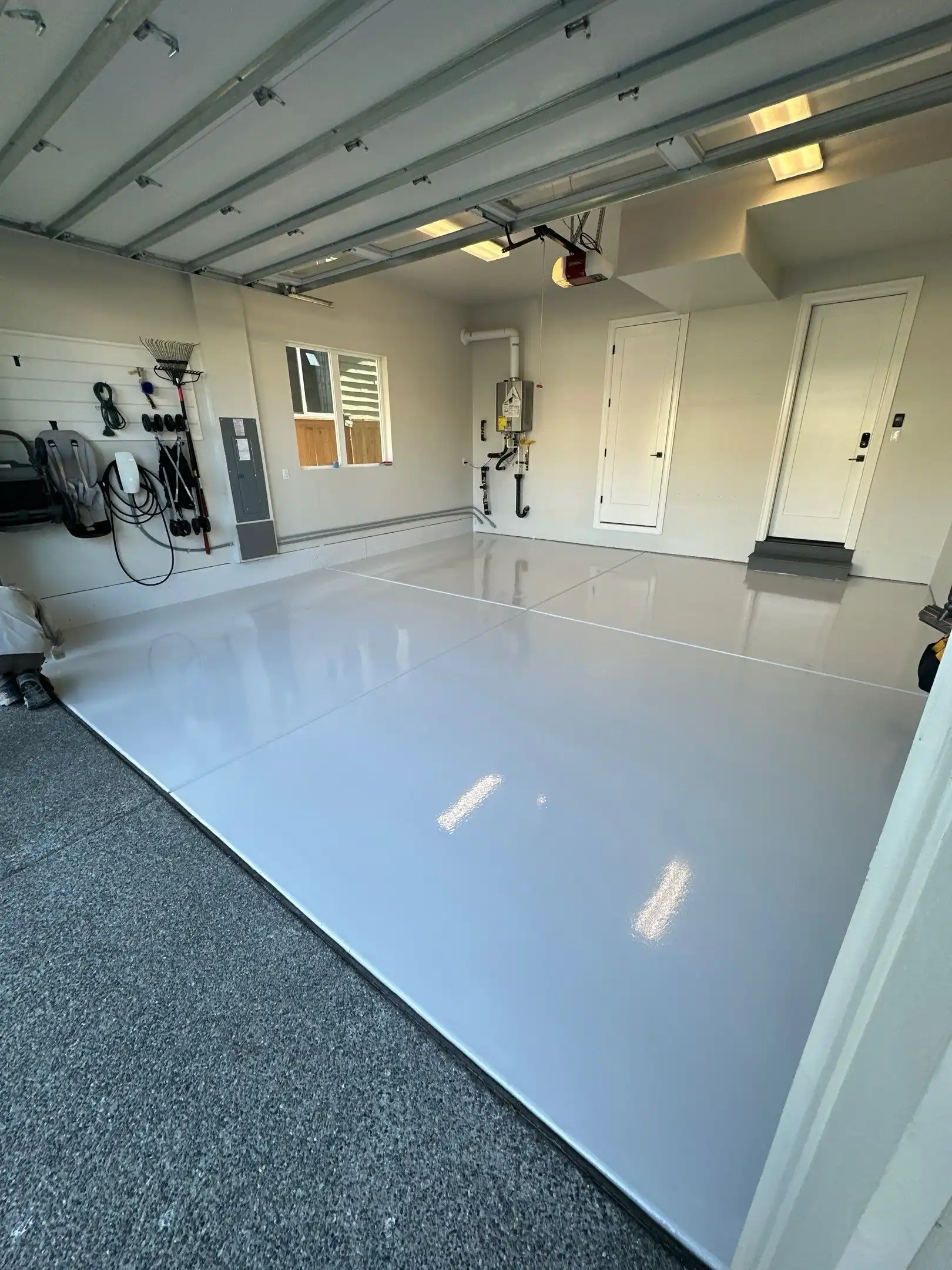 Olympus White solid color polyurea garage floor in Sammamish with tool wall and bikes