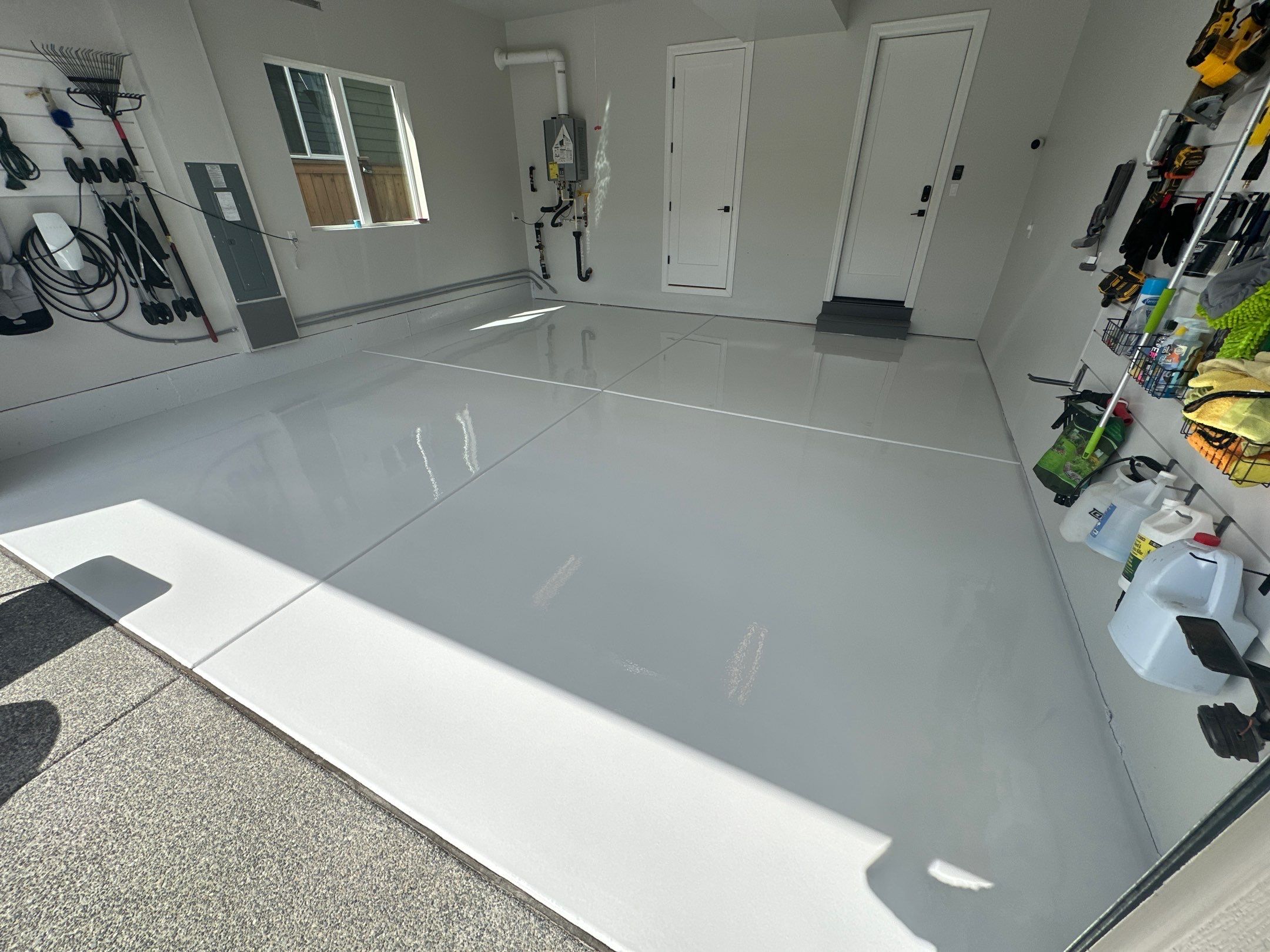 Solid color garage floor with tool storage wall and window in Sammamish