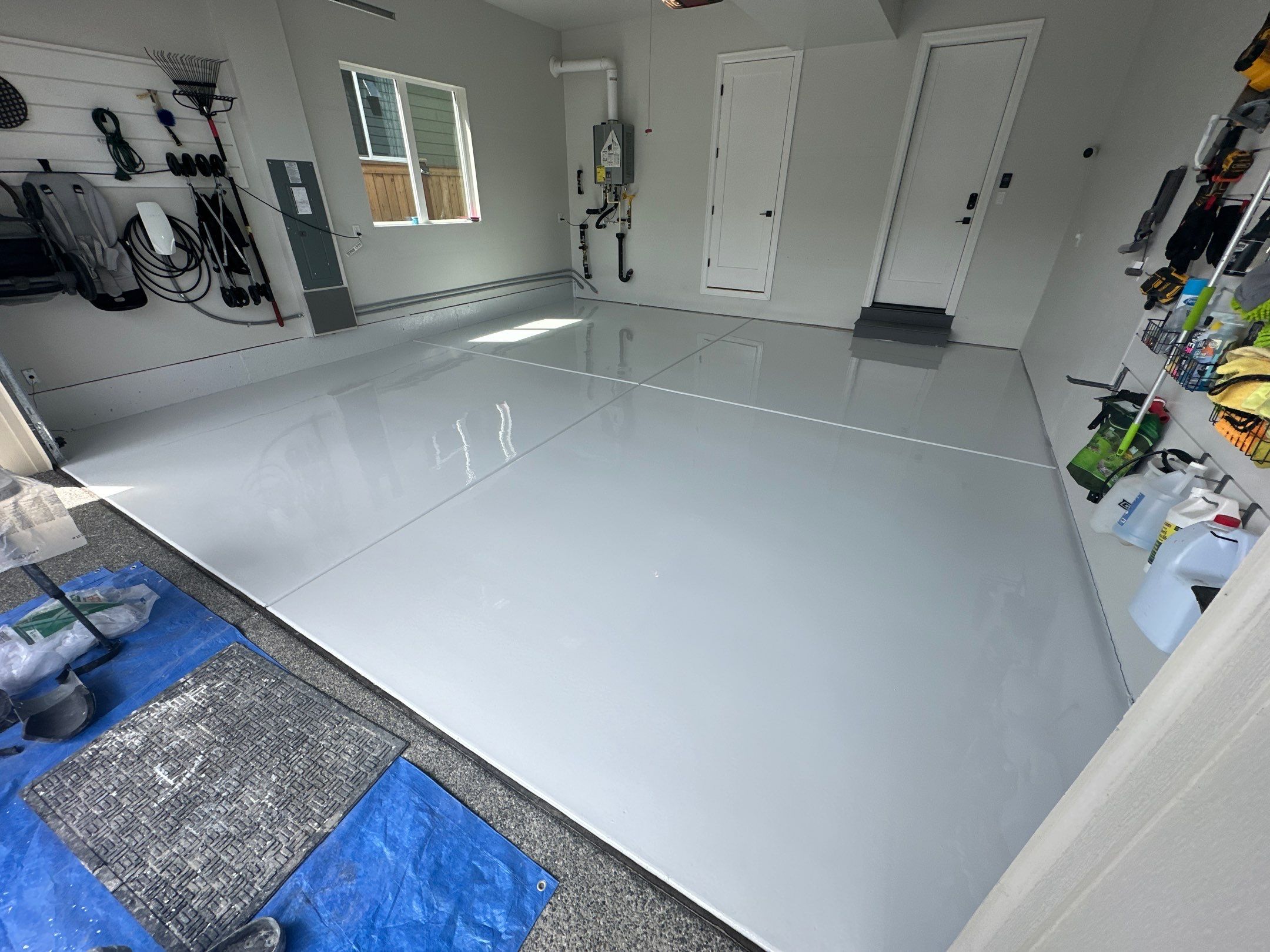 Olympus White solid garage floor with yard tools on the wall, Sammamish